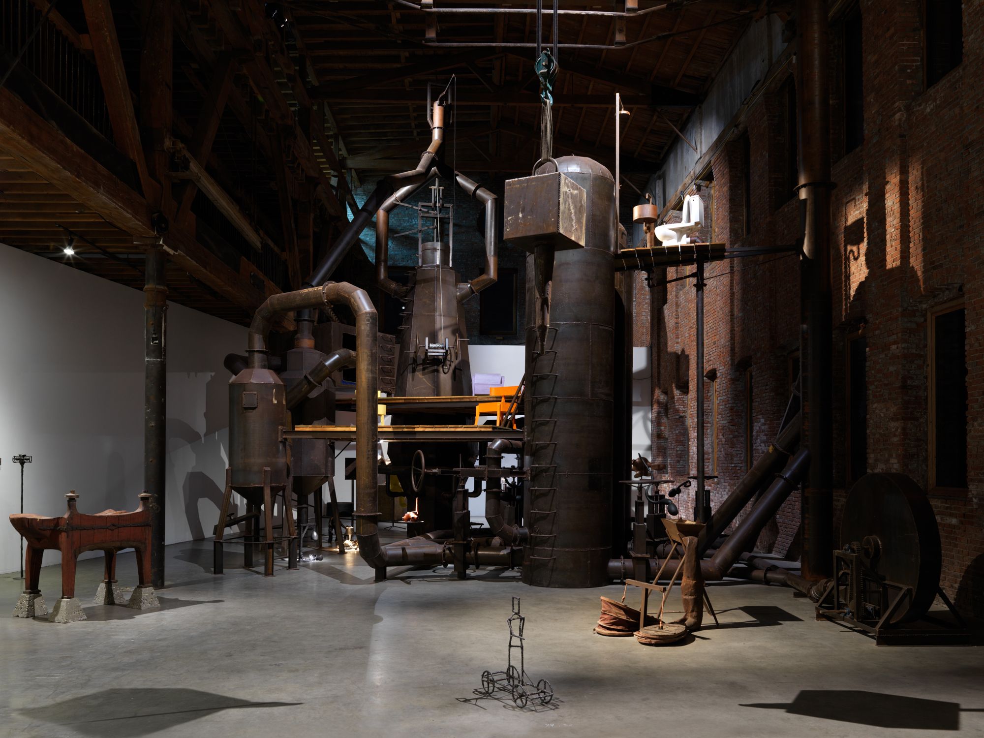 A massive, mock blast furnace fills an enormous warehouse space.