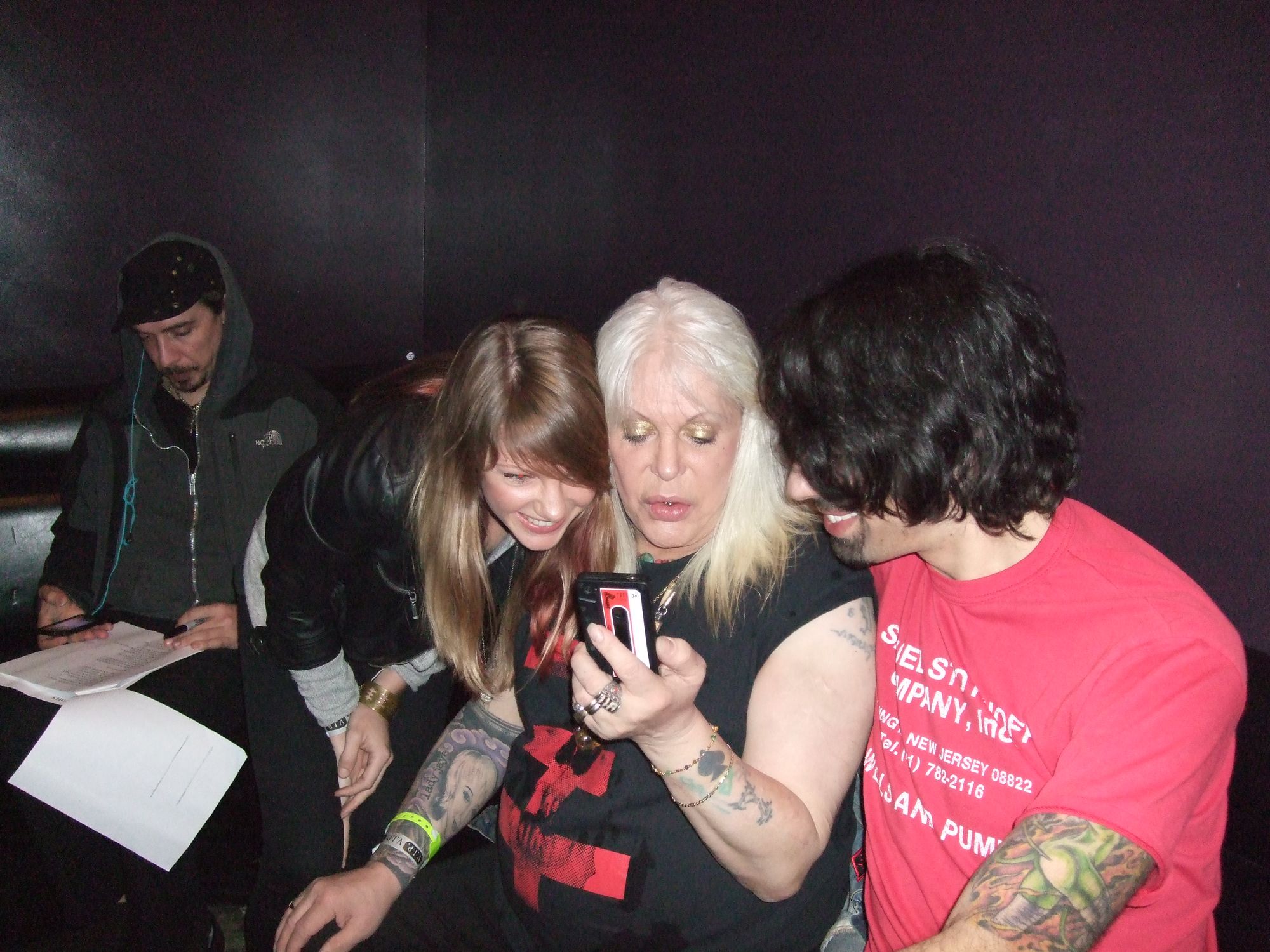 Three people crowded around a phone