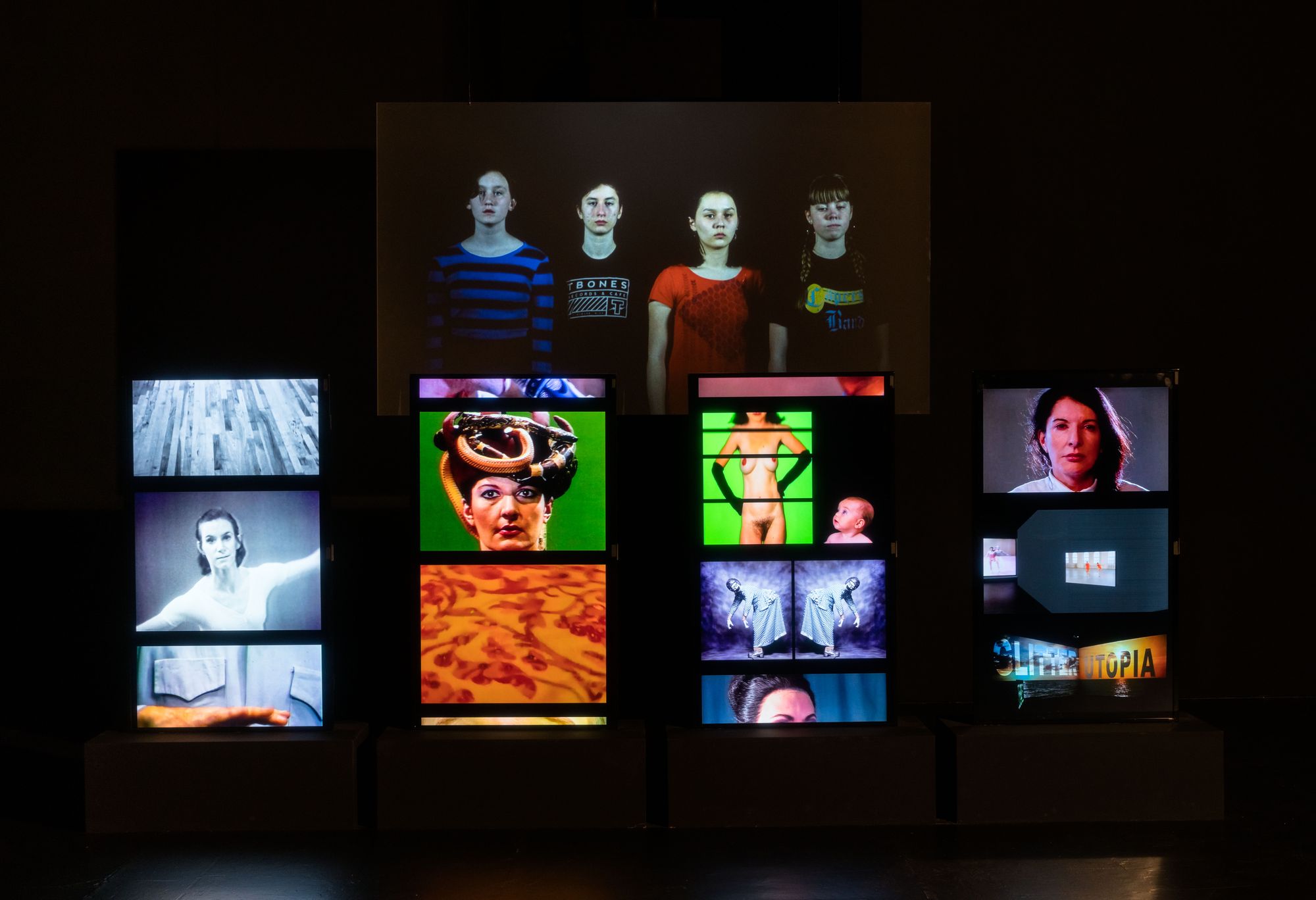 A cluster of TV monitors show various videos Charles Atlas's works.