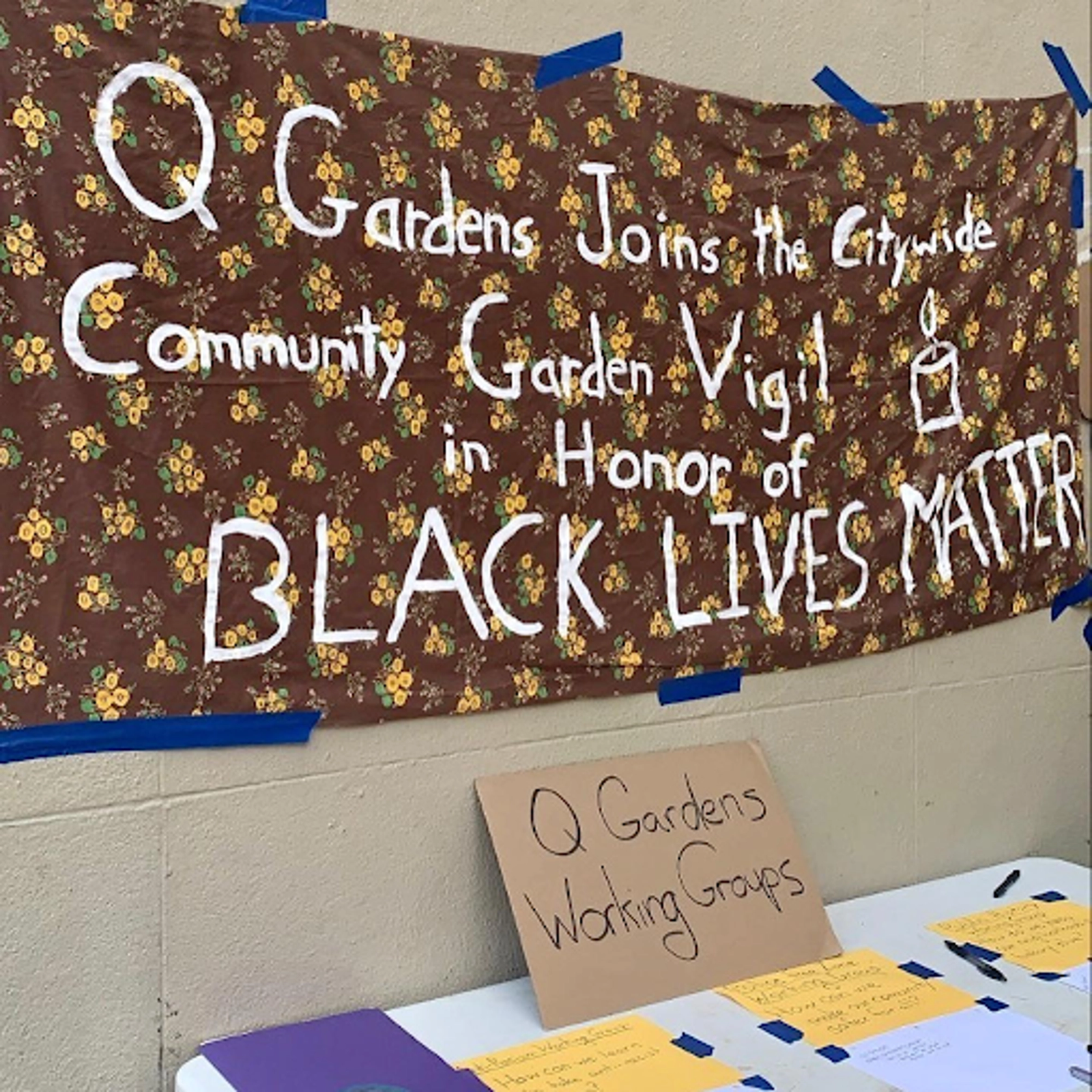 Banner saying "Q Gardens joins the citywide community garden vigil in honor of Black Lives Matter."