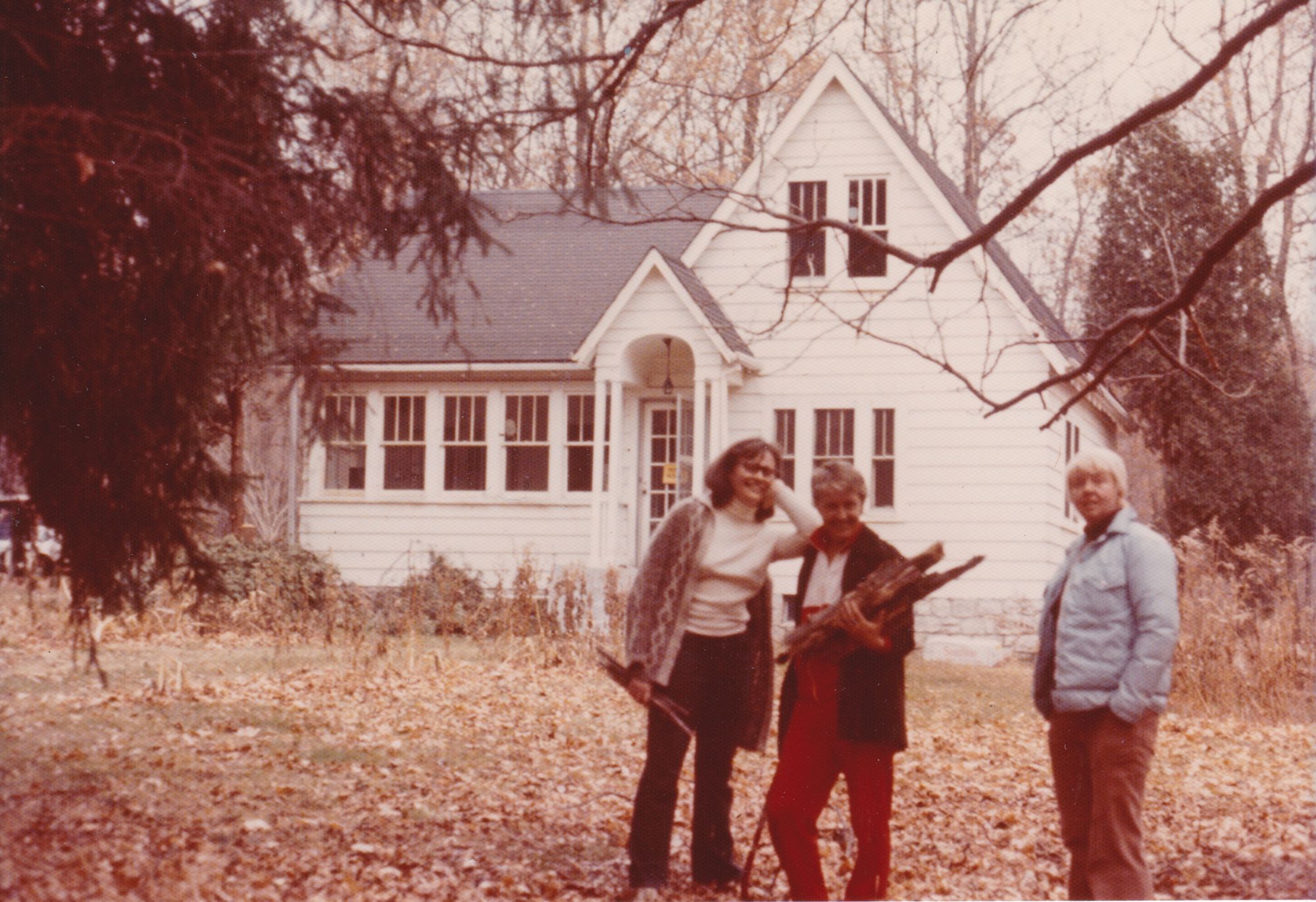 Three women standing in front of a house