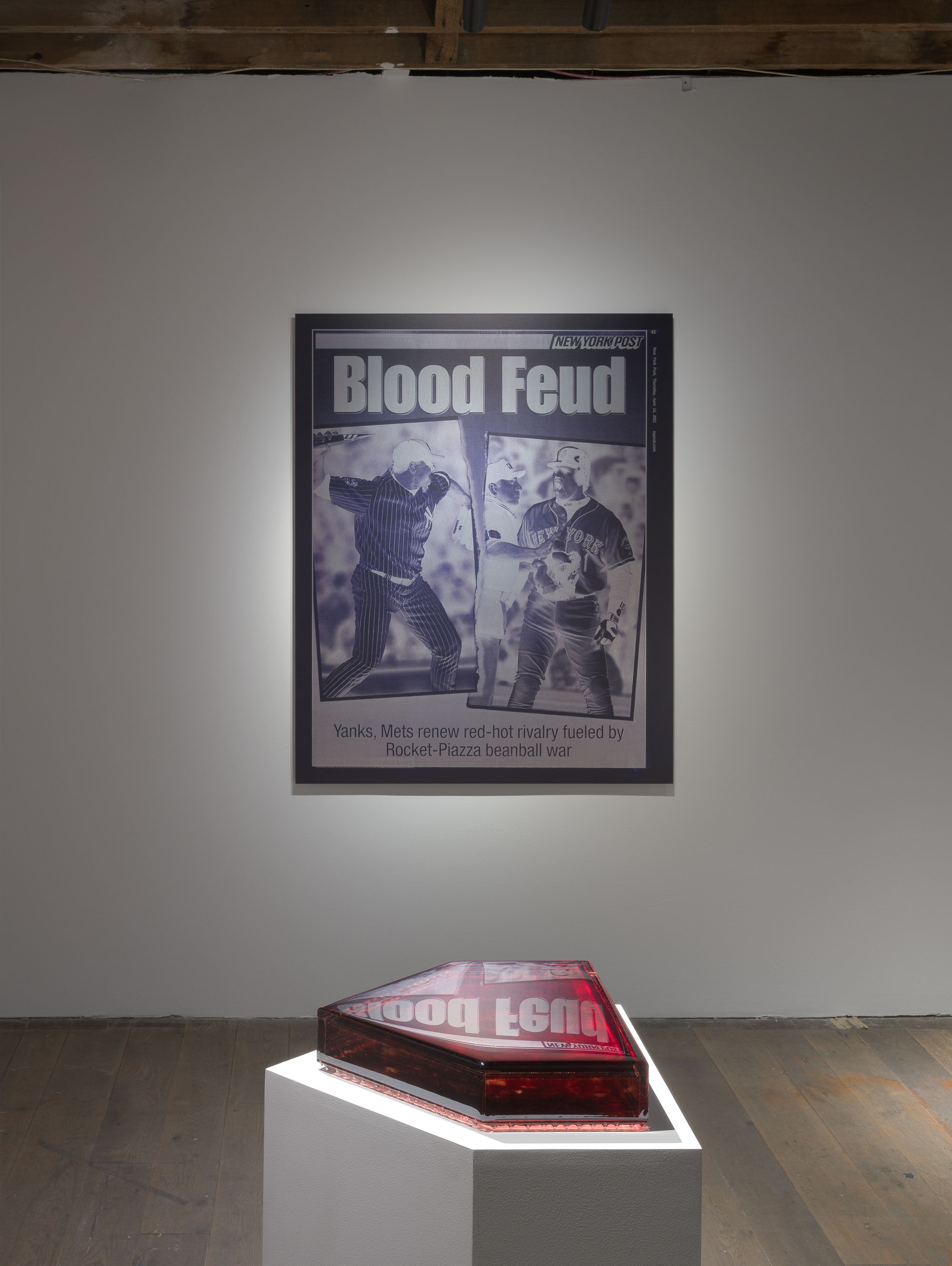 Large print of newspaper covers that reads "Blood Feud" on the wall.