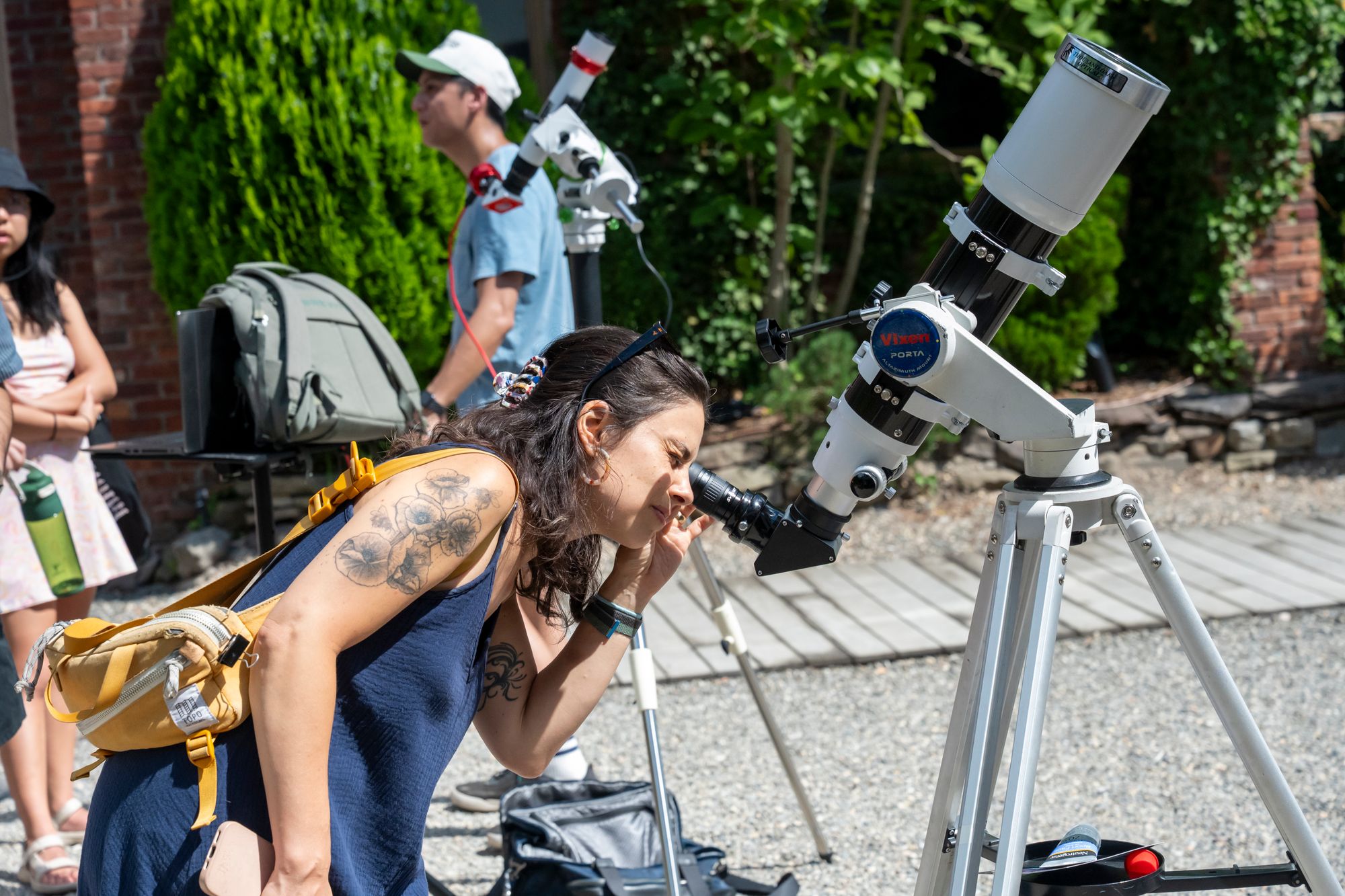 People looking into a telescope in Pioneer Works garden