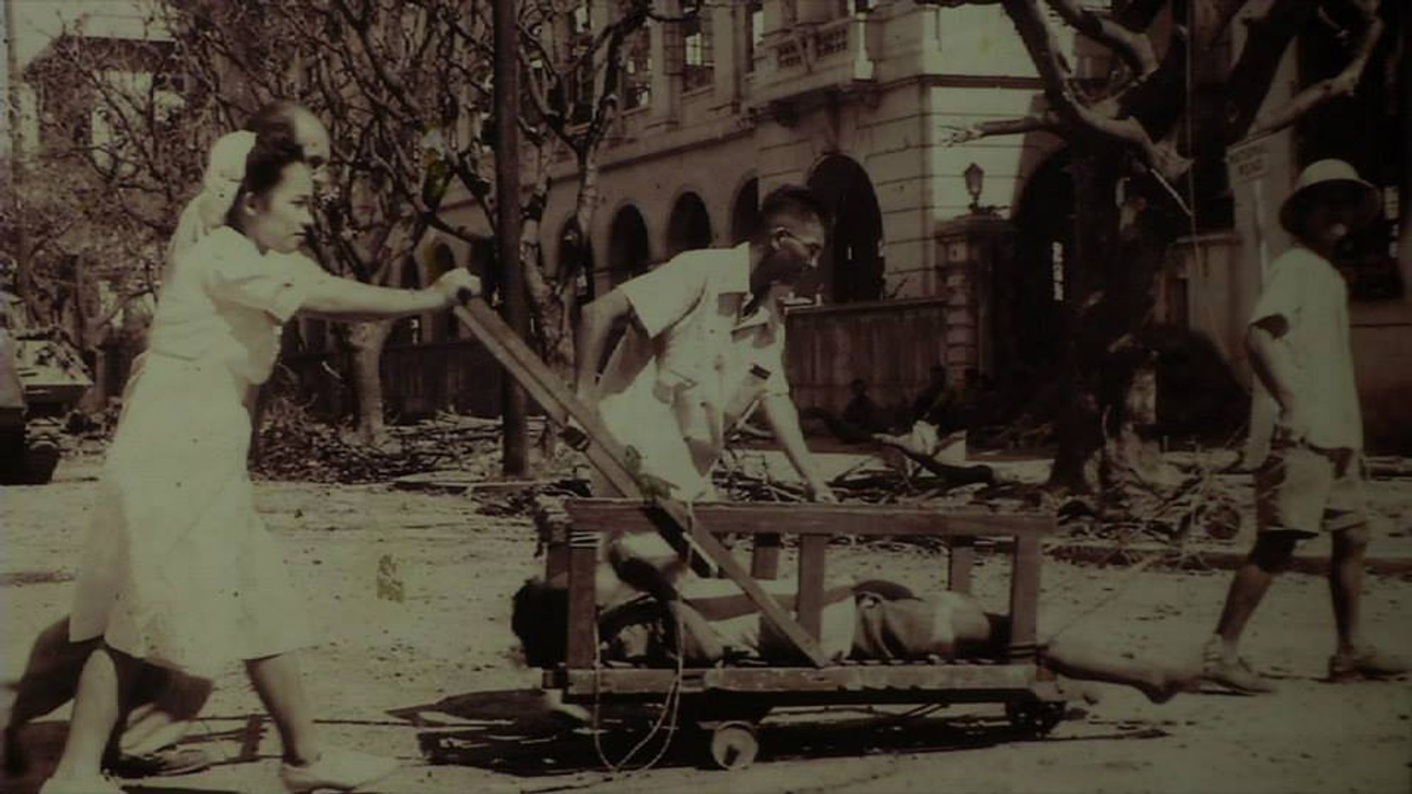 A sepia-toned image of a man and woman cleaning the city streets with a pushcart.