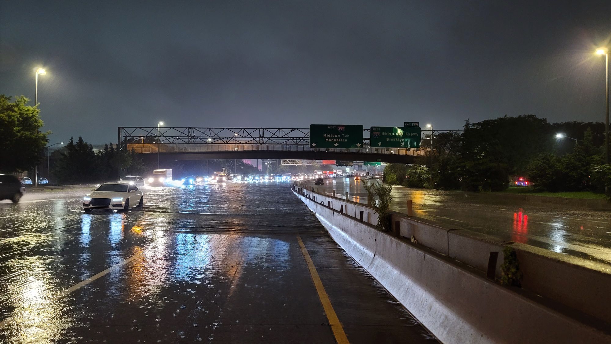 Cars driving through a flooded Long Island Expressway