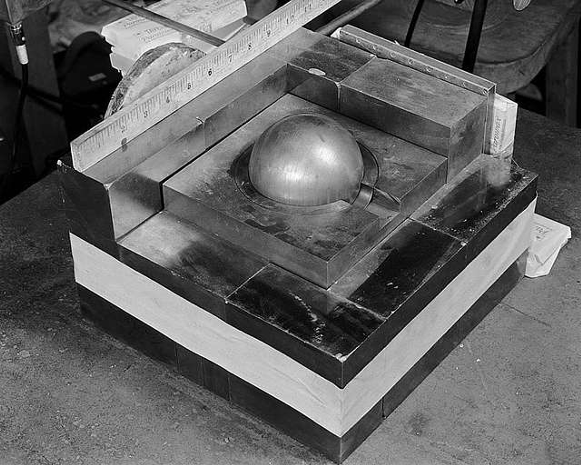 Black and white photo of a sphere of plutonium surrounded by neutron reflecting blocks