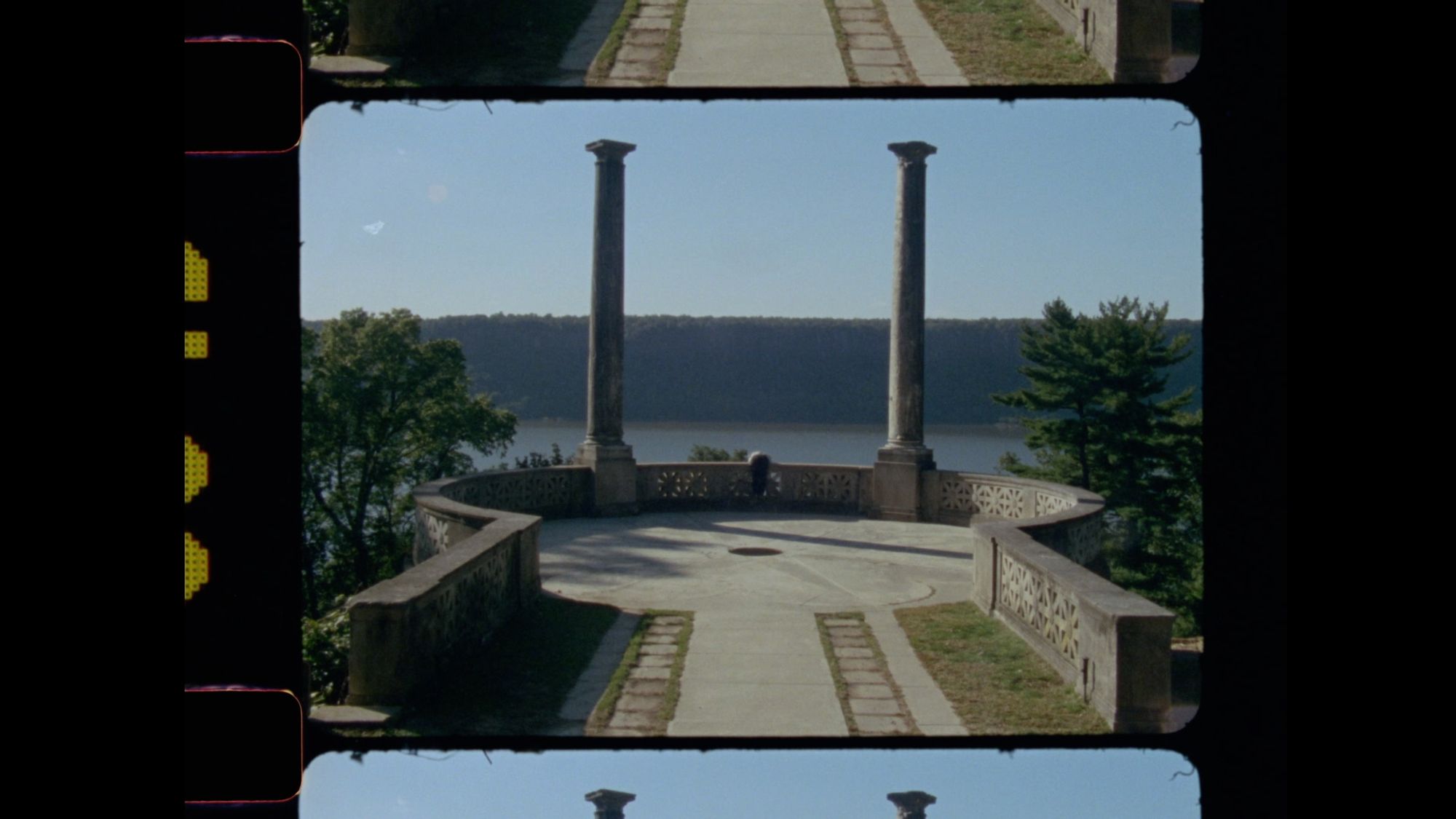 A film reel of an outlook, framed by two pillars.