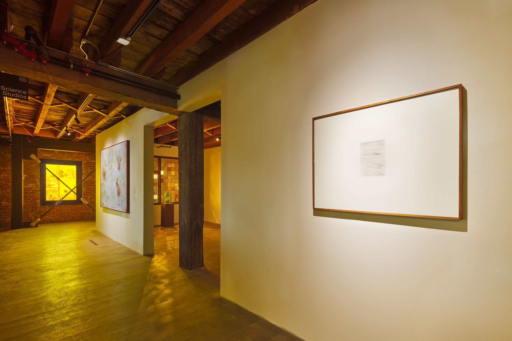 A glimpse into a gallery space at Pioneer Works, with yellow glazes applied to the windows 