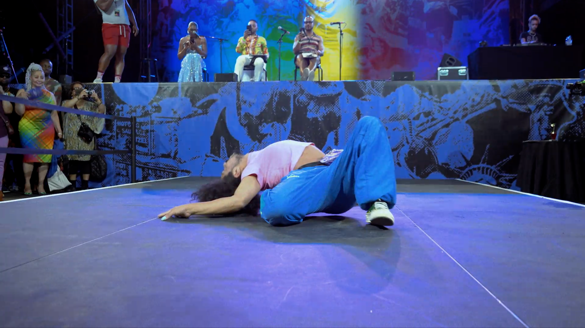 Person lying in a back split on the colorful stage of a ball show