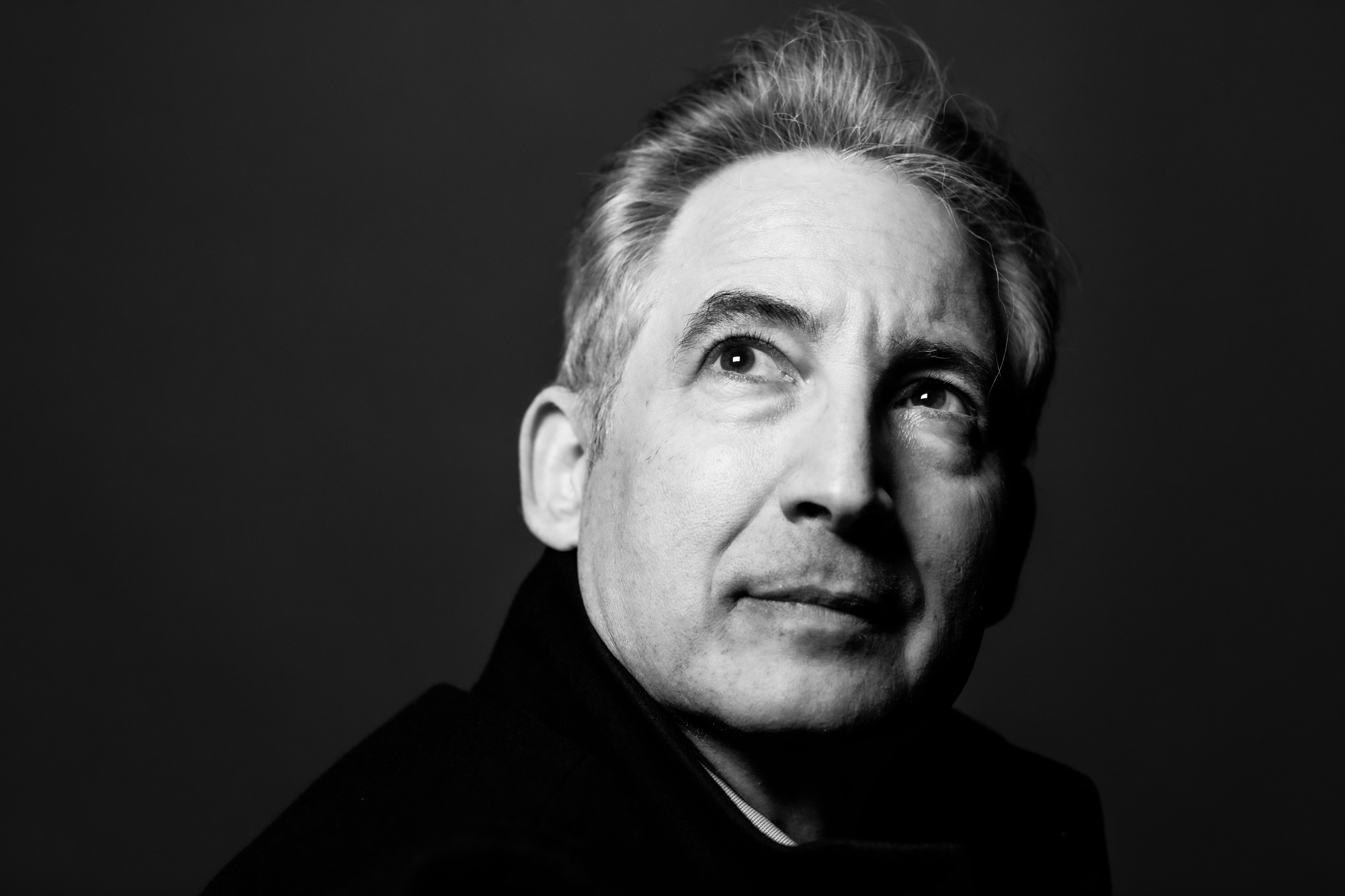 A black and white photograph of Brian Greene