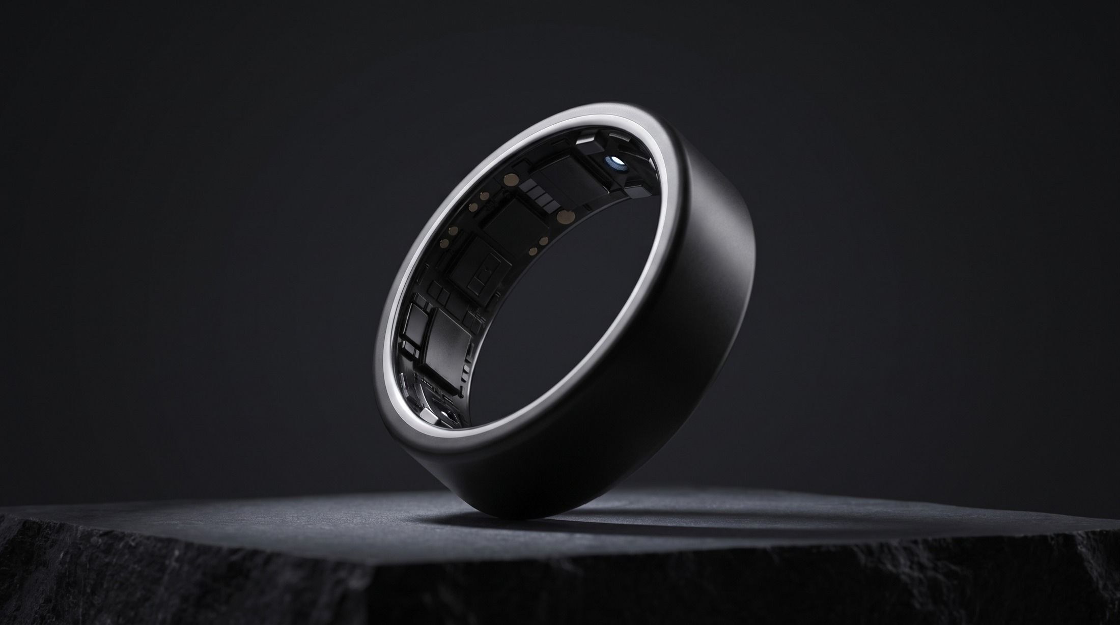Sculptural silver smart ring in a dark studio