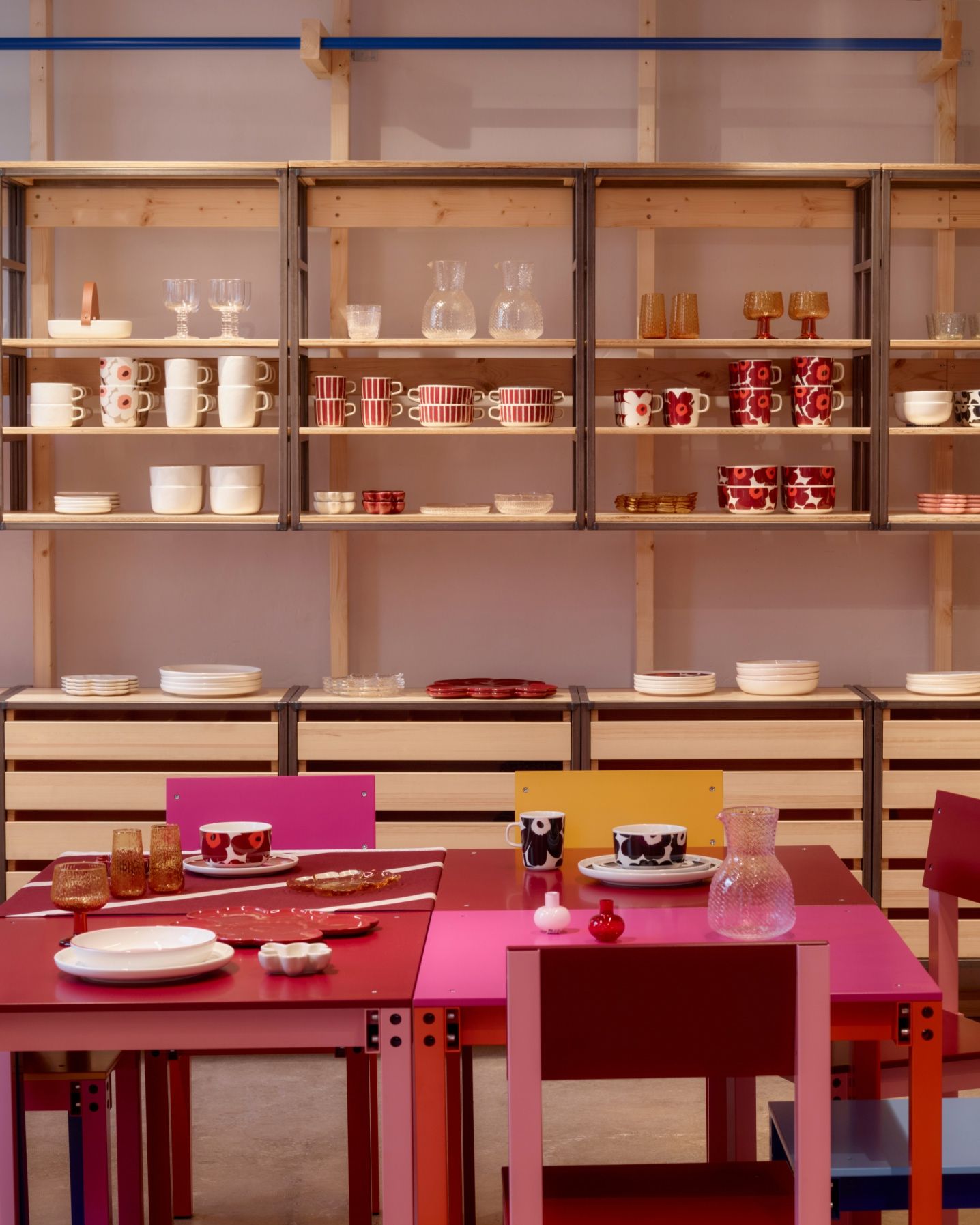 Front view: Display of Marimekko home items such as mugs, plates, tumblers.