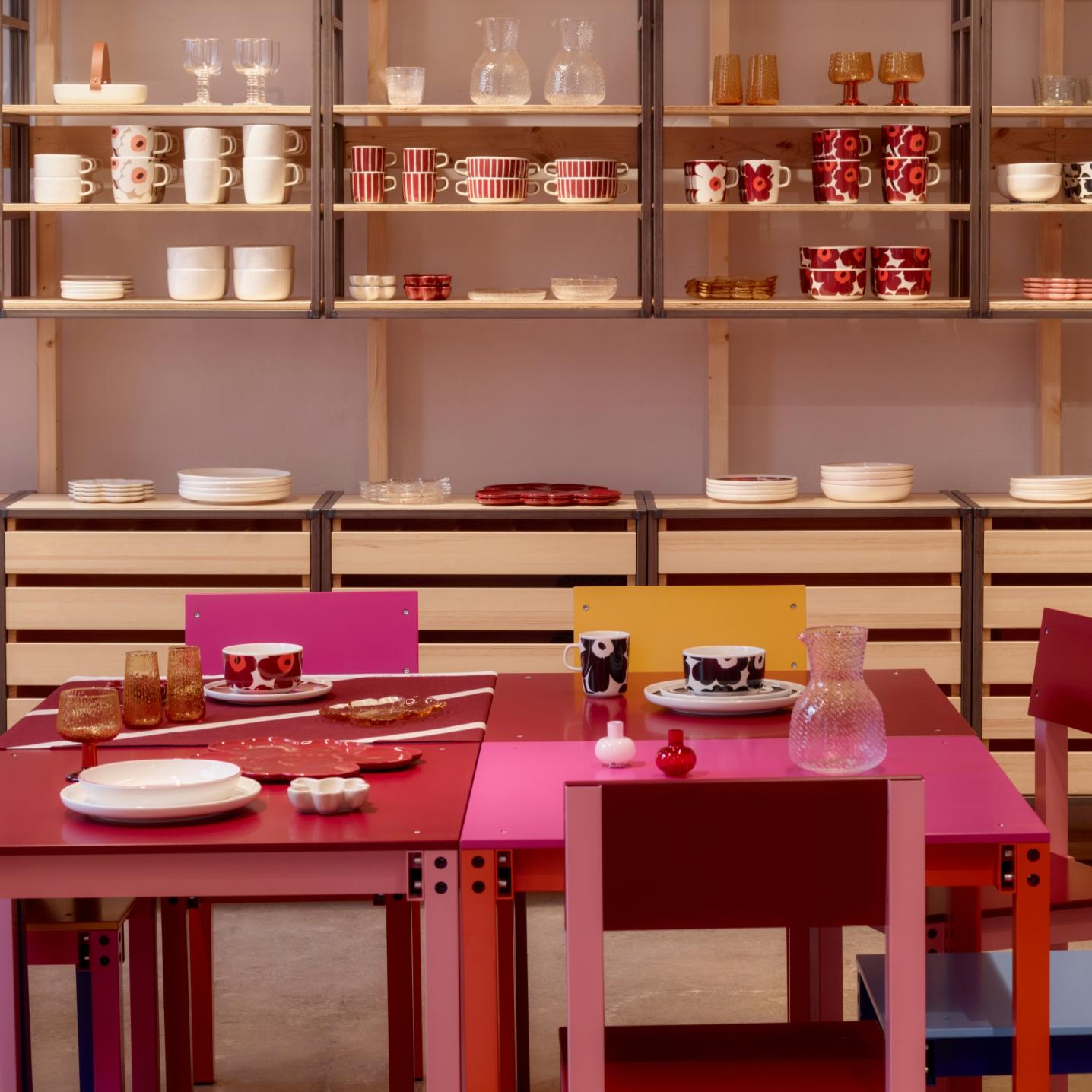 Front view: Display of Marimekko home items such as mugs, plates, tumblers.