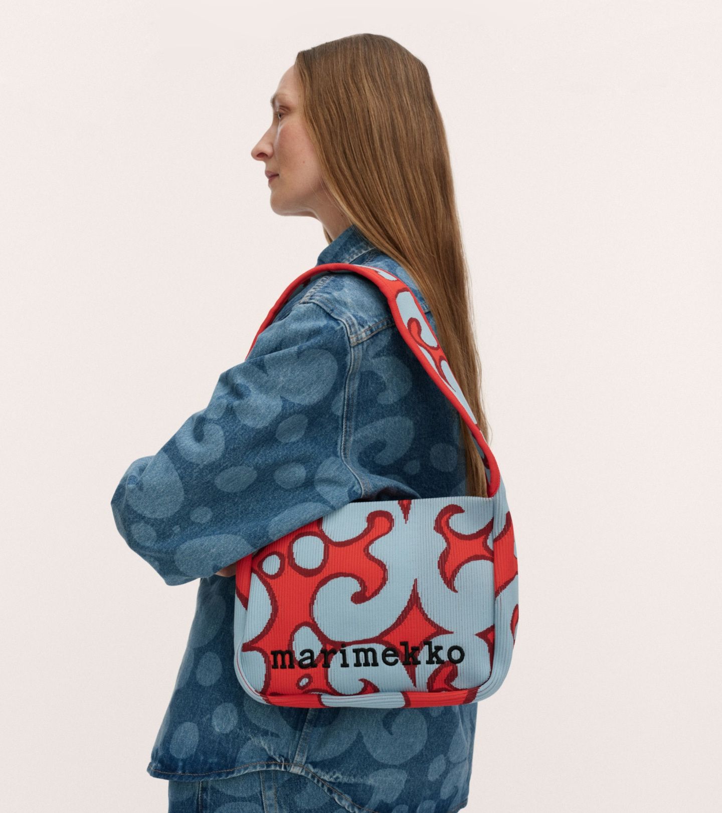 Model carrying a knitted shoulderbag in red and blue Keidas print.