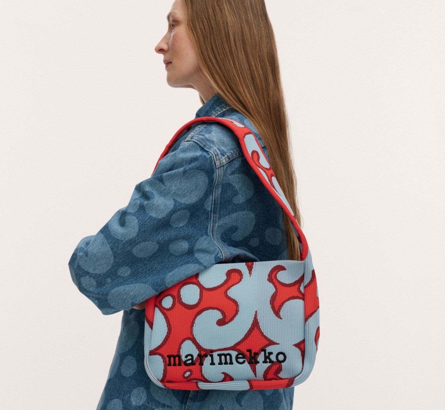 Model carrying a knitted shoulderbag in red and blue Keidas print.