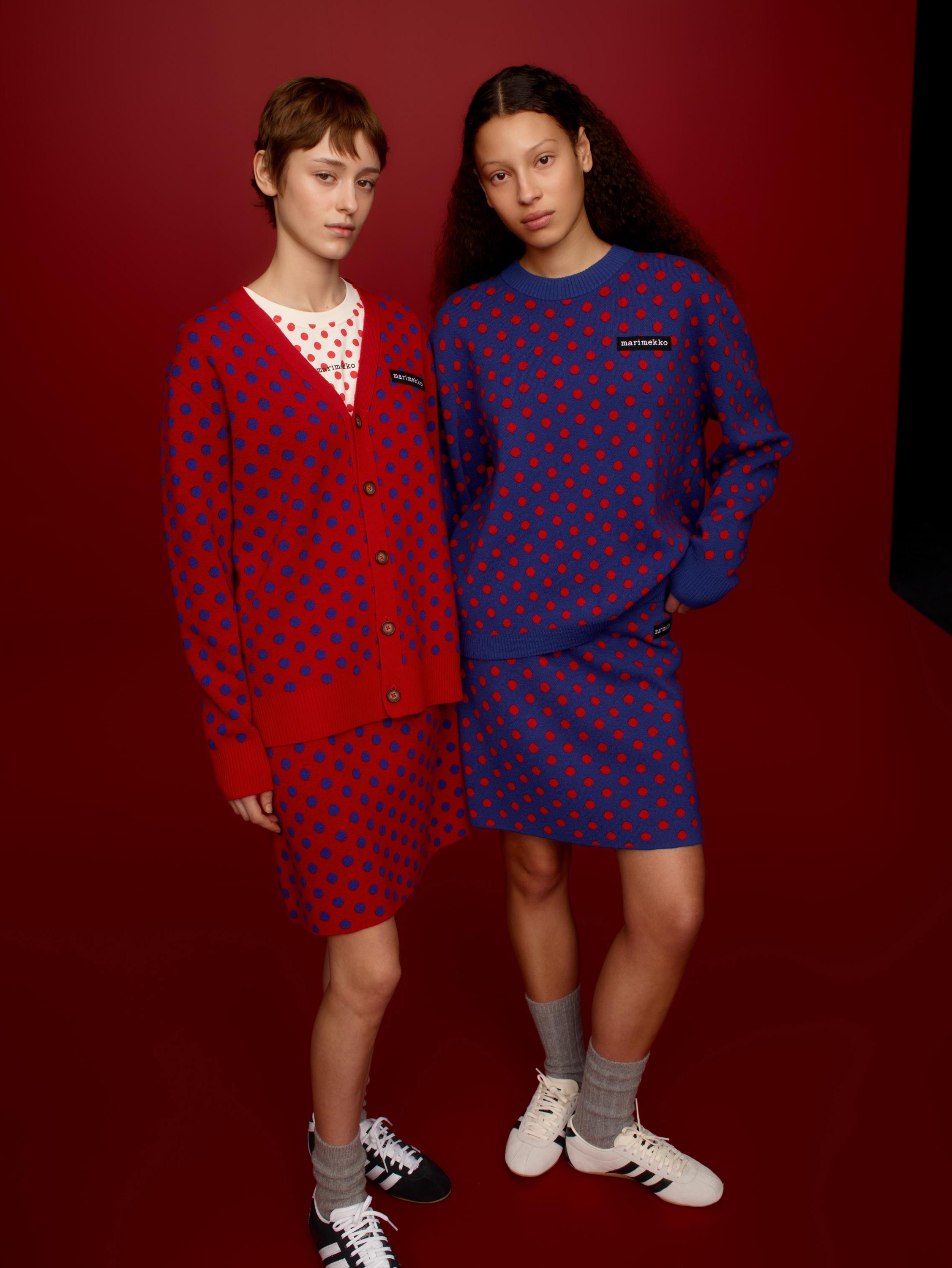Two models wearing Marimekko Kioski knits and knitted skirts in red and purple Pallo print.