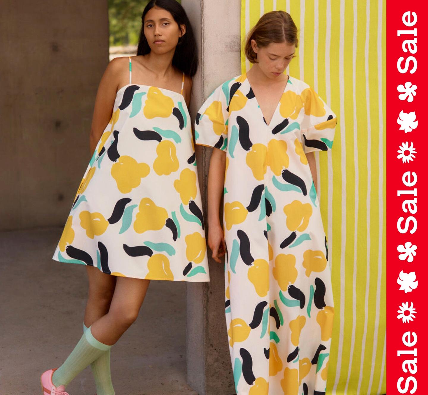 Models wearing Pelit dress and Taivut dress in Lemmitty print. On the side a vertical textline ''Sale''.