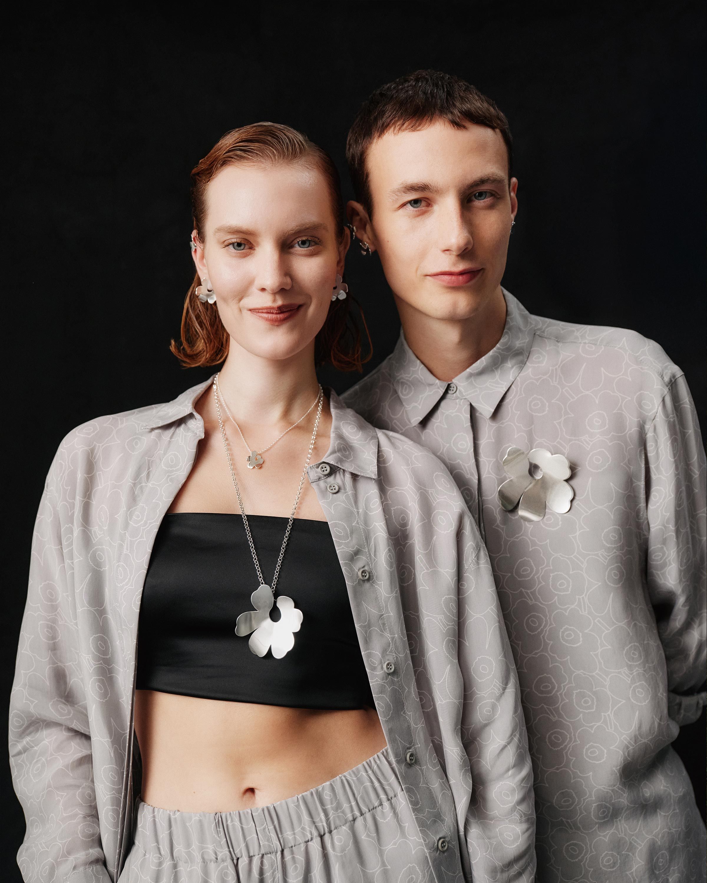 Models wearing Unikko-shaped Kalevala and Marimekko necklace and earrings.