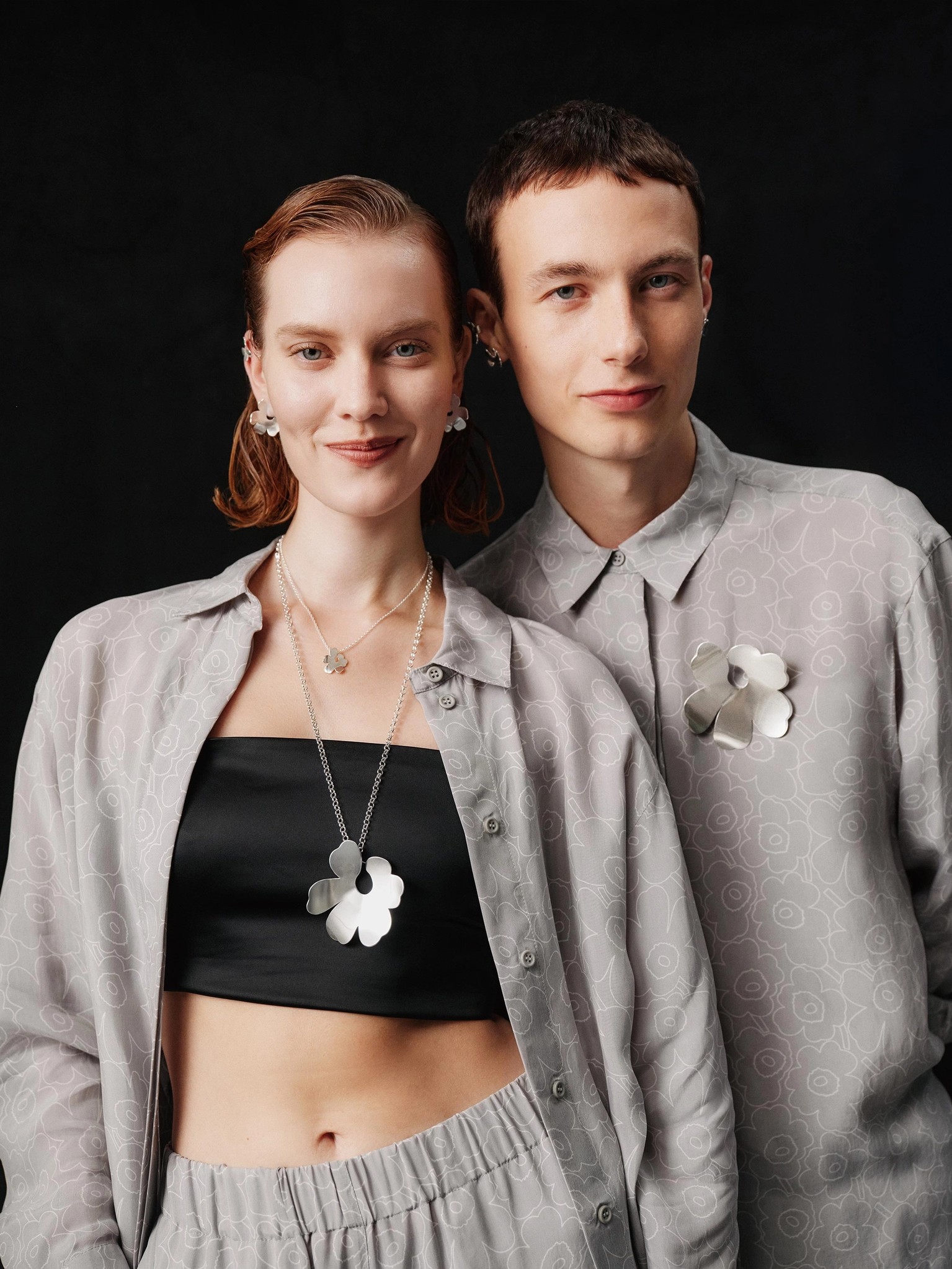 Models wearing Unikko-shaped Kalevala and Marimekko necklace and earrings.