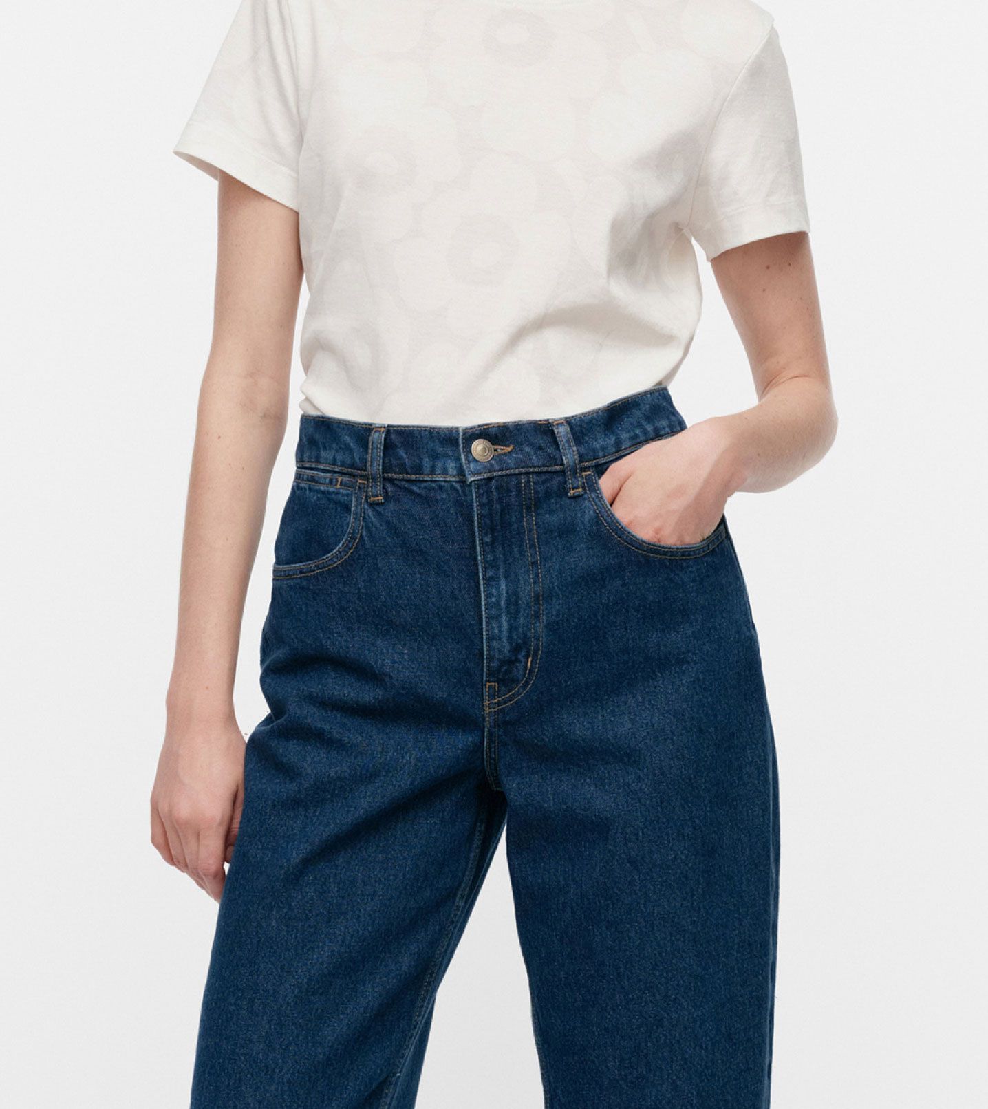 Model wearing dark blue Marimekko Maridenim jeans and a white t-shirt with Unikko print.