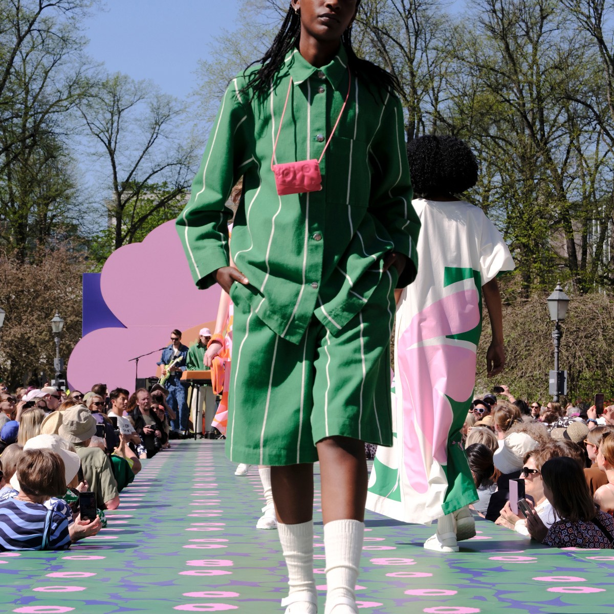 Model dressed in a green shirt and shorts.