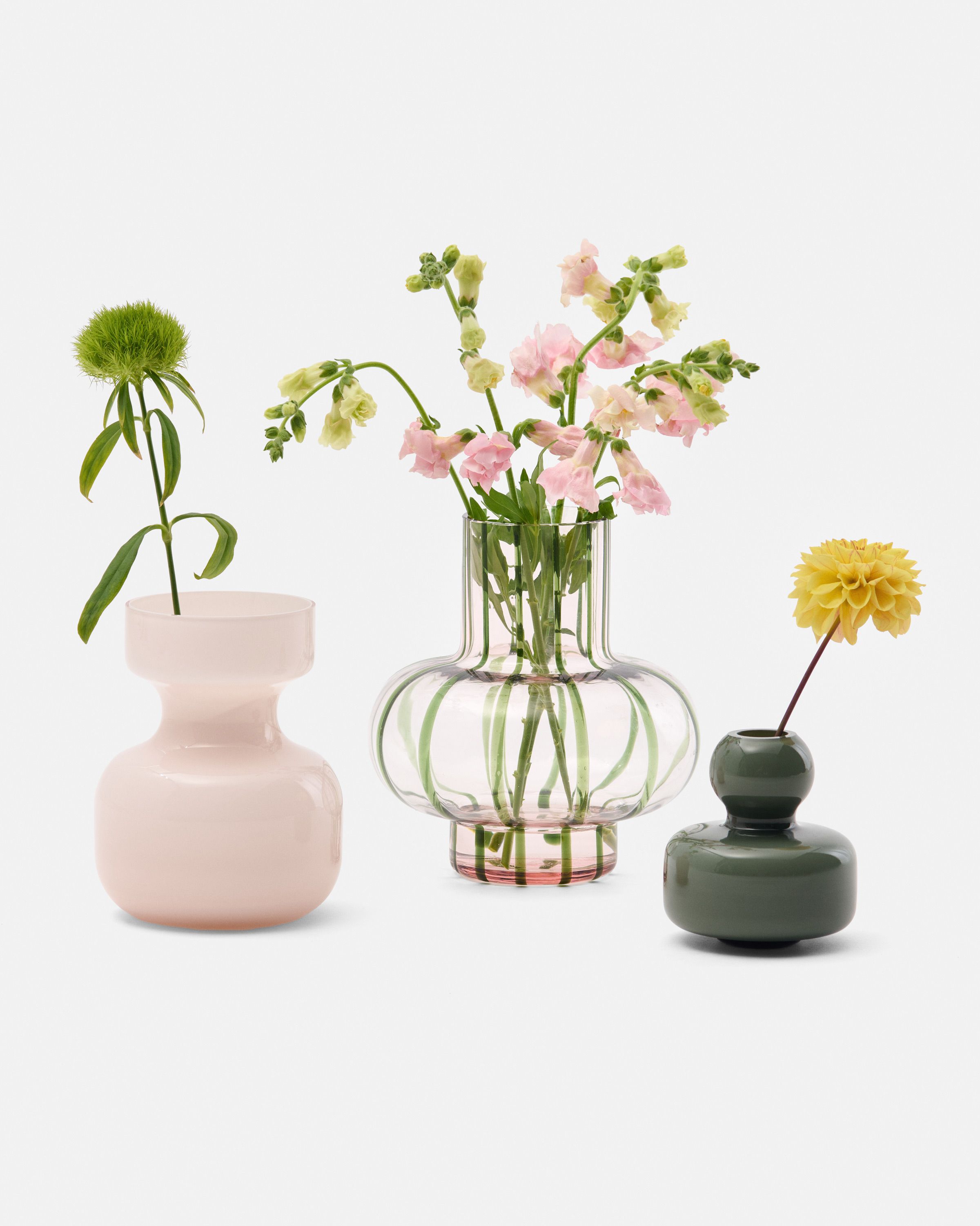 A collection of vases in different colors with flowers.