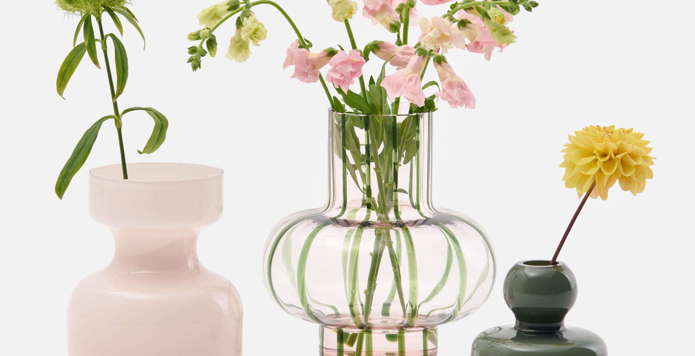 A collection of vases in different colors with flowers.
