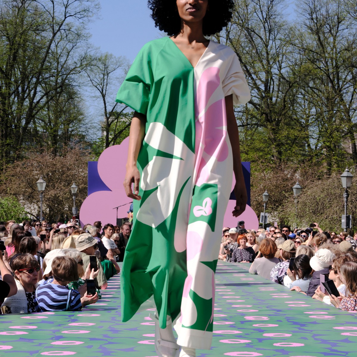 Model dressed in a long green-pink-white dress