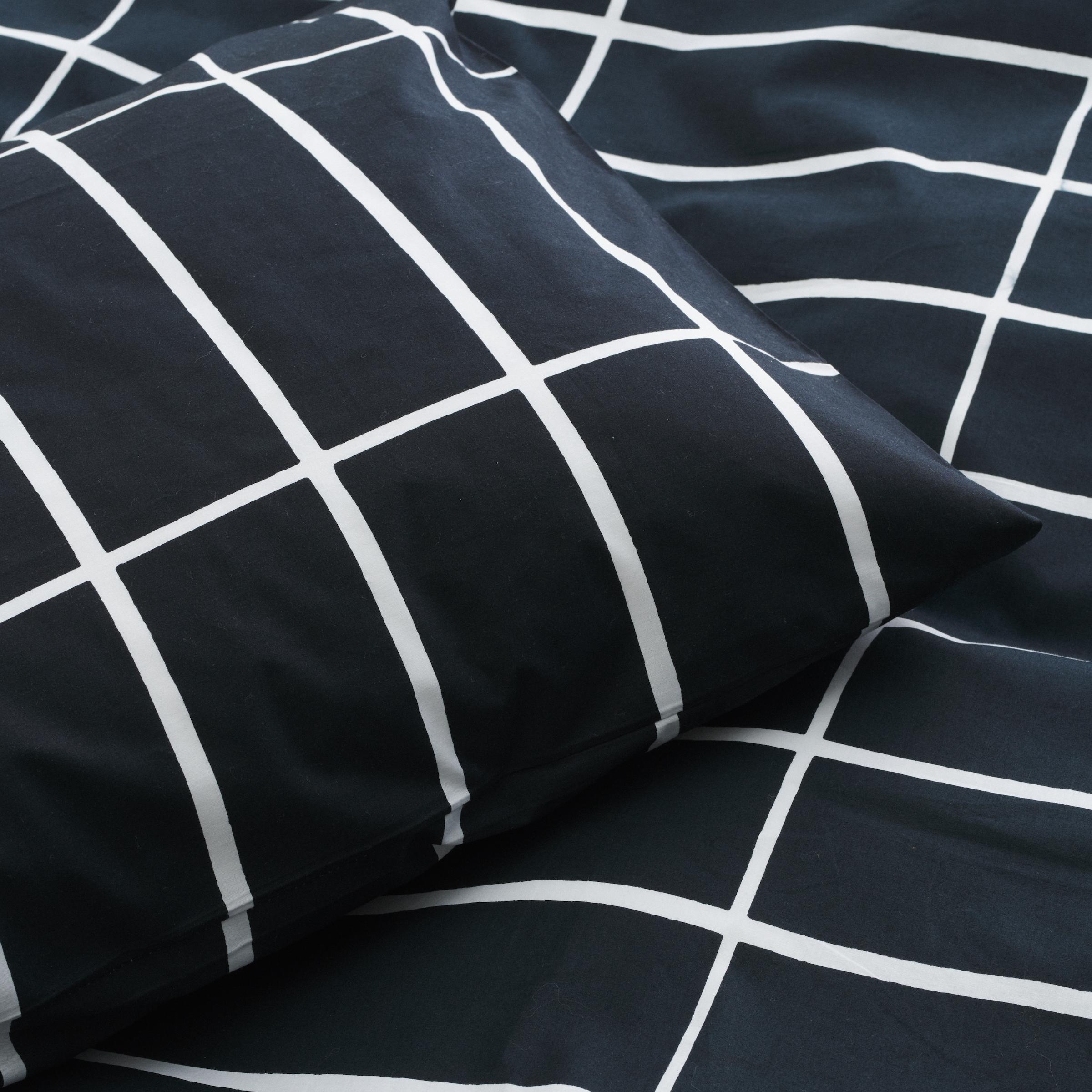 Mustavalkoiset lakanat Tiiliskivi-kuosissa.