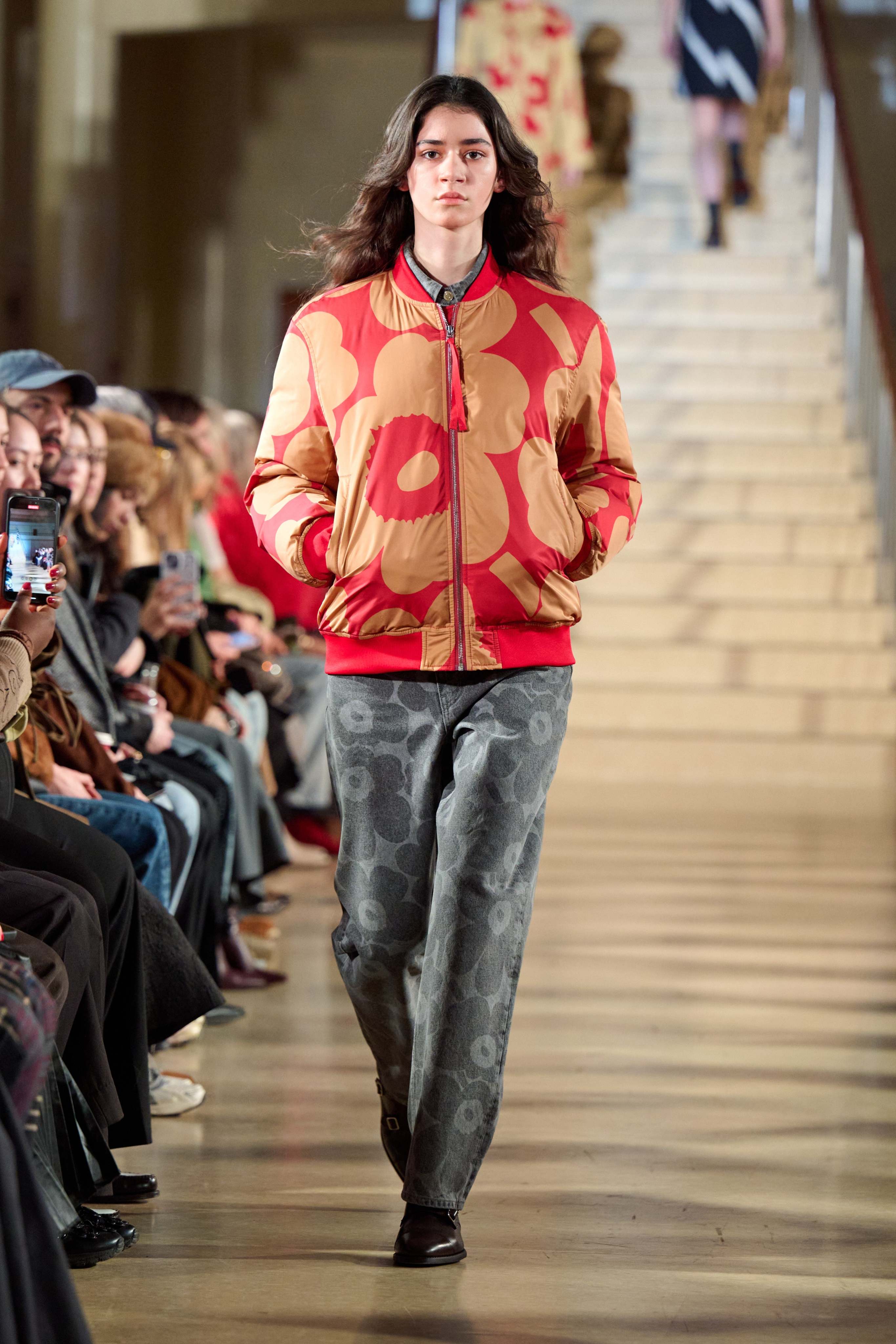 Model wearing a red-beige padded coat in Unikko-print.