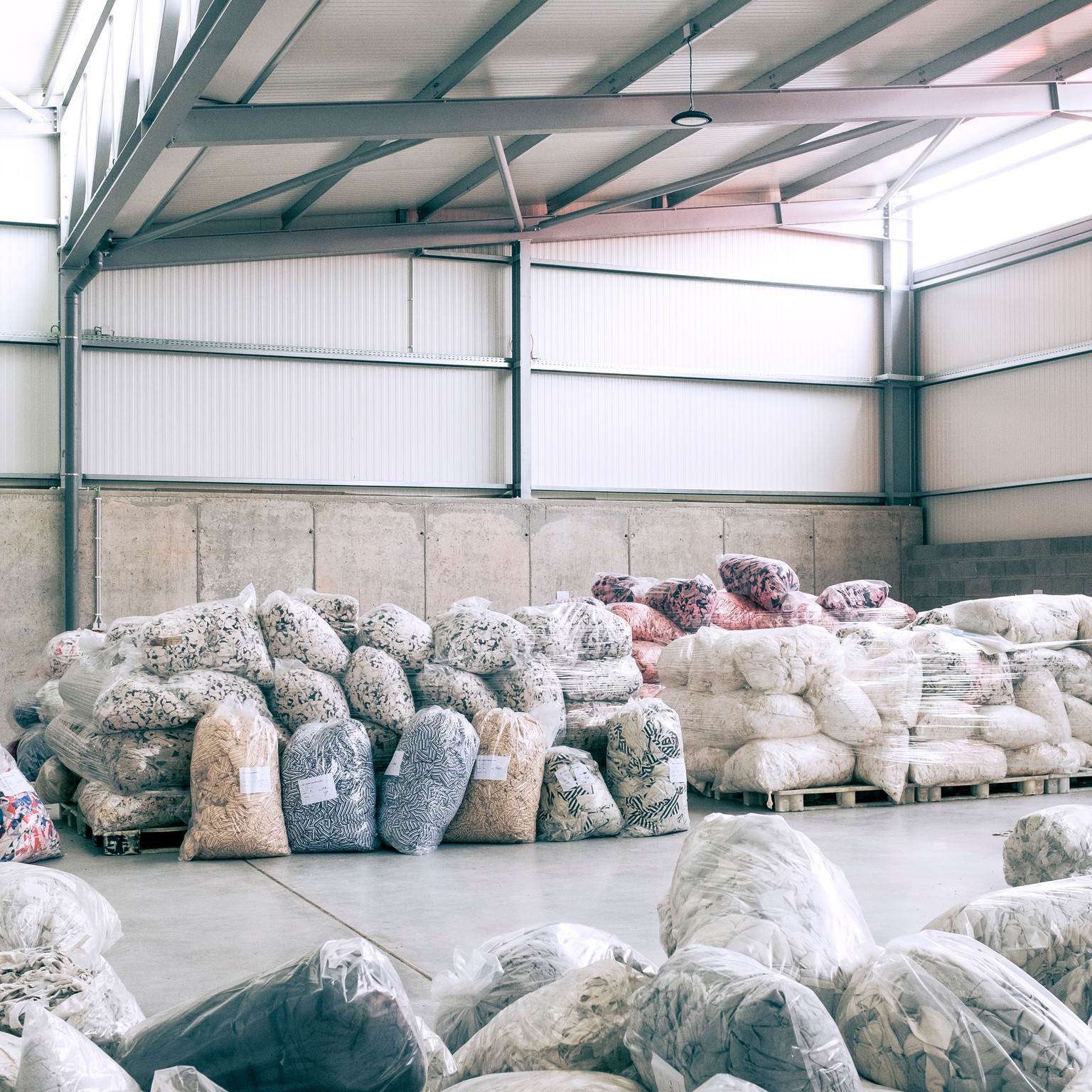 Textile waste material collected into plastic bags.