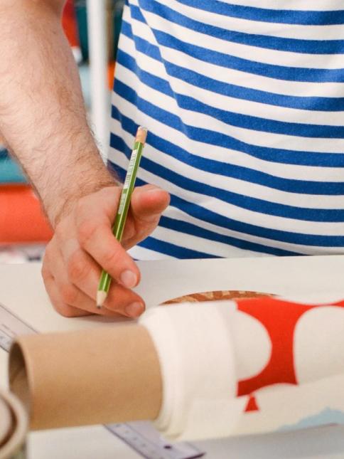 Designer in tasaraita t-shirt designing new Marimekko products