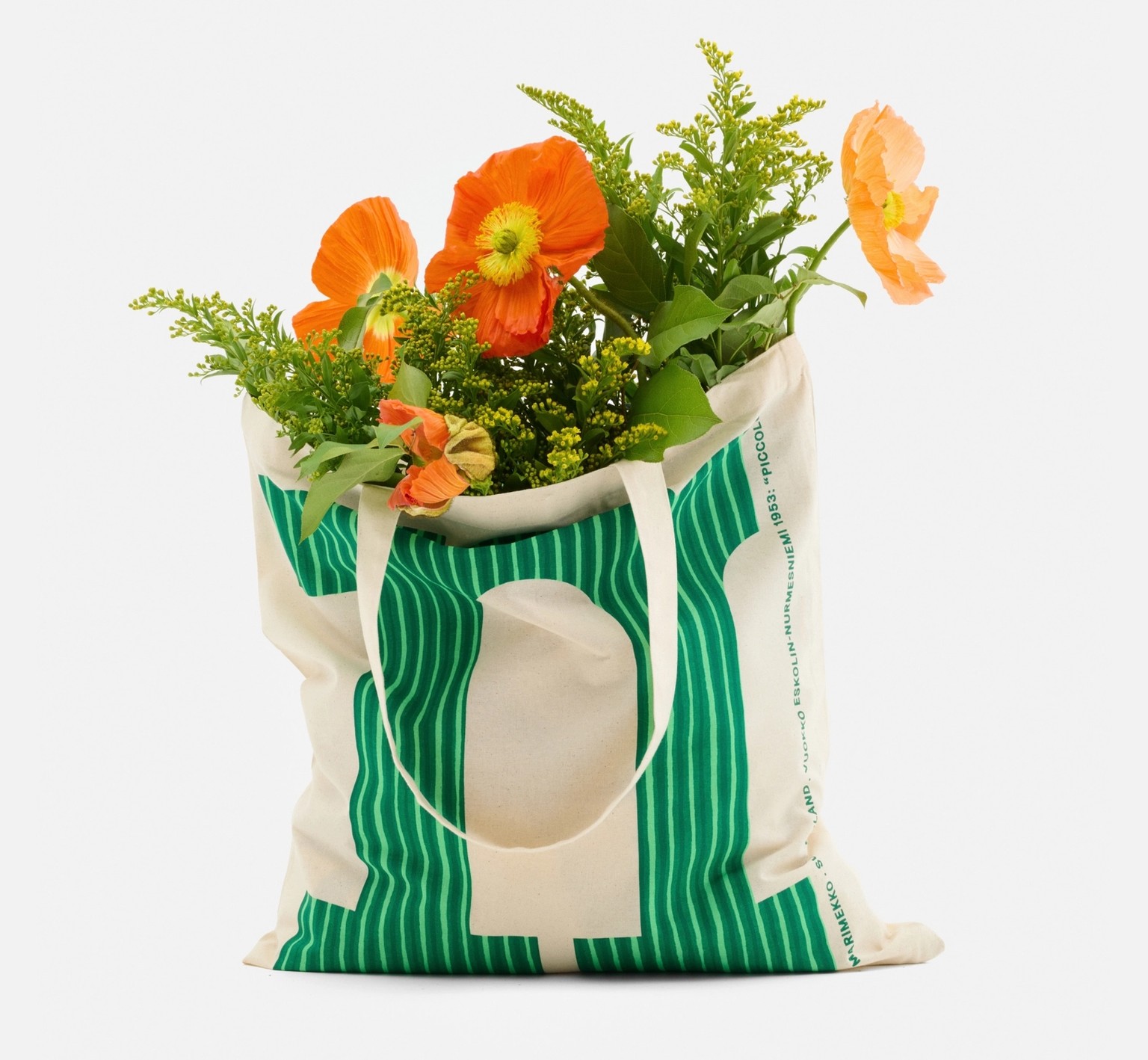 Kangaskassi, jossa on Piccolo-painatuksella kuvioitu vihreä M-kirjain ja kukkia.