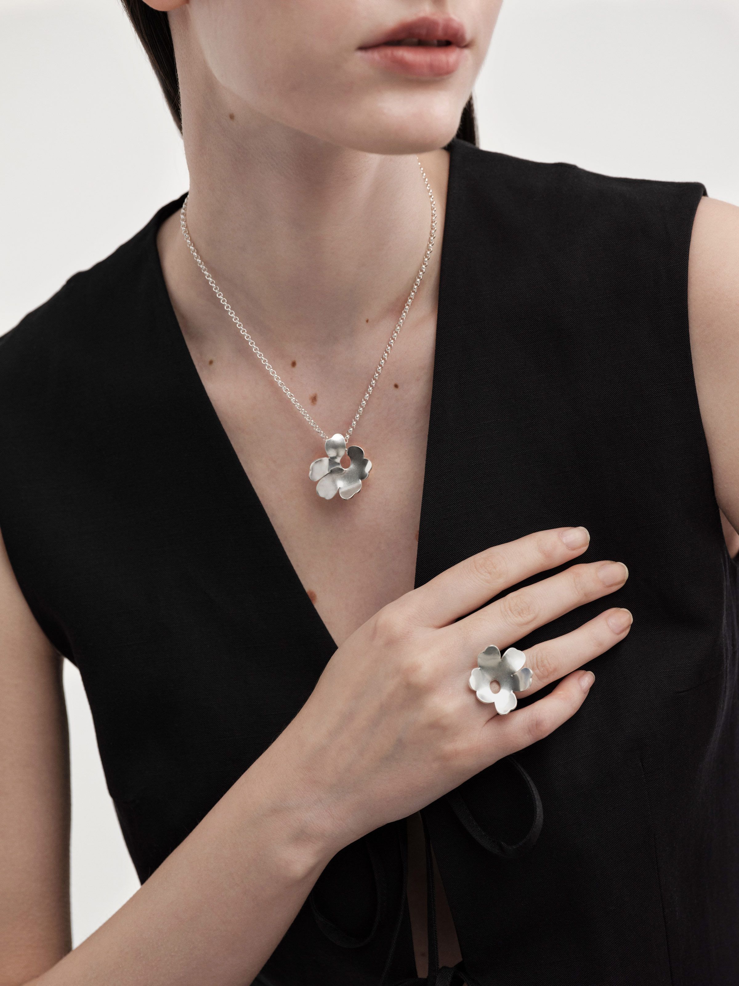 The model has a silver Unikko ring and necklace.