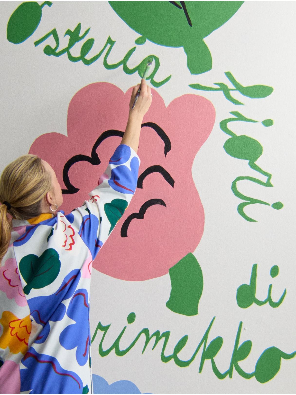 A woman painting a pink flower.