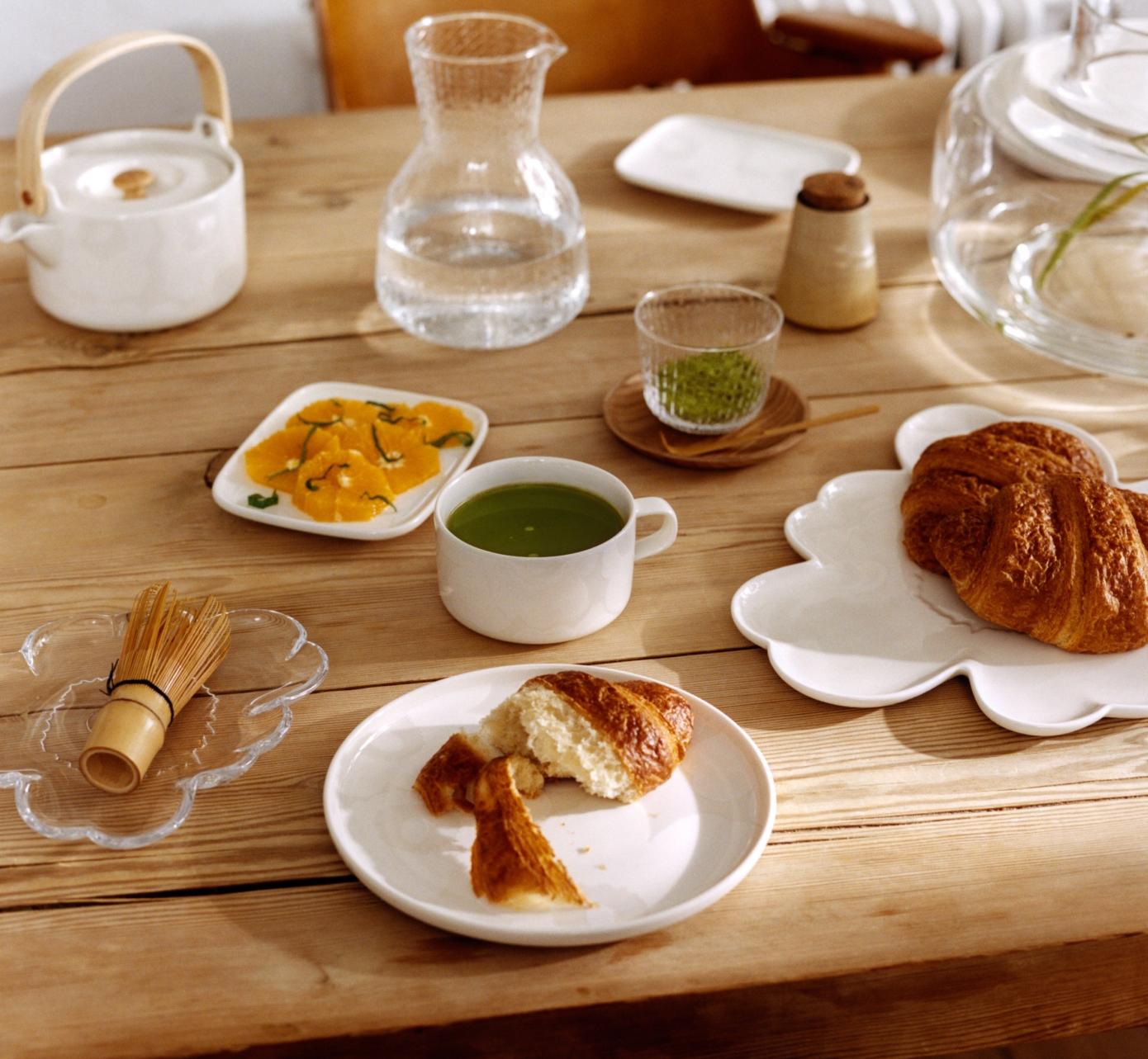 Pöytäkattaus jossa Unikko-muotoinen lautanen ja muita Oiva-astioita.