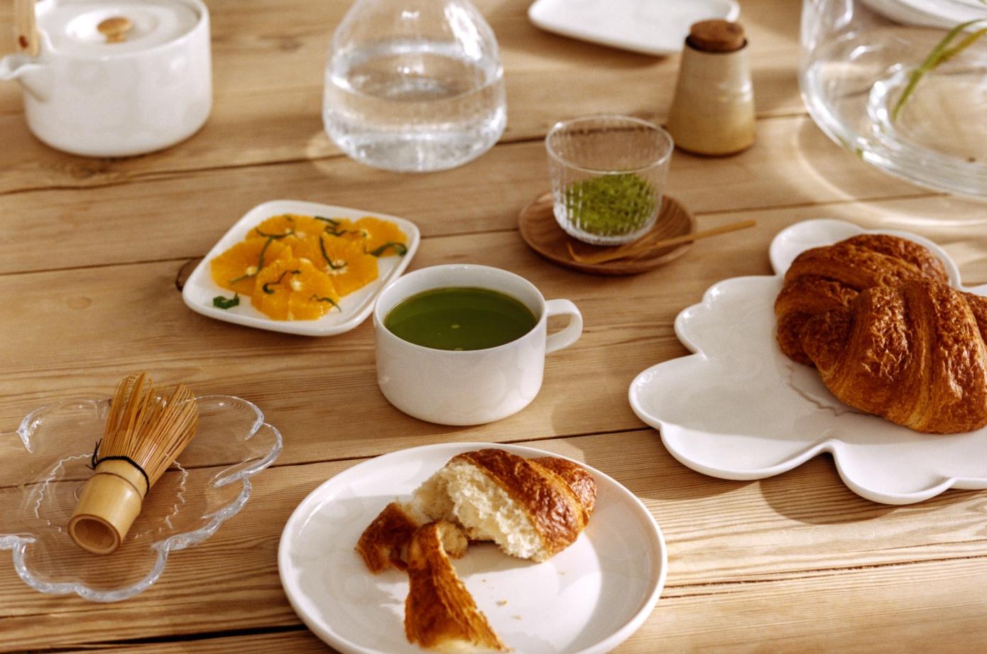 Pöytäkattaus jossa Unikko-muotoinen lautanen ja muita Oiva-astioita.