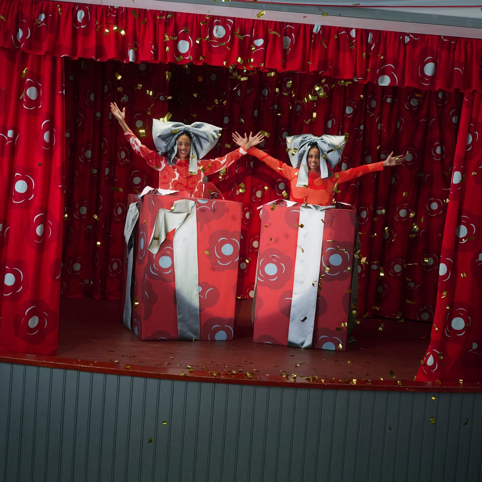 Kaksi mallia hyppäämässä ulos lahjapaketeista.