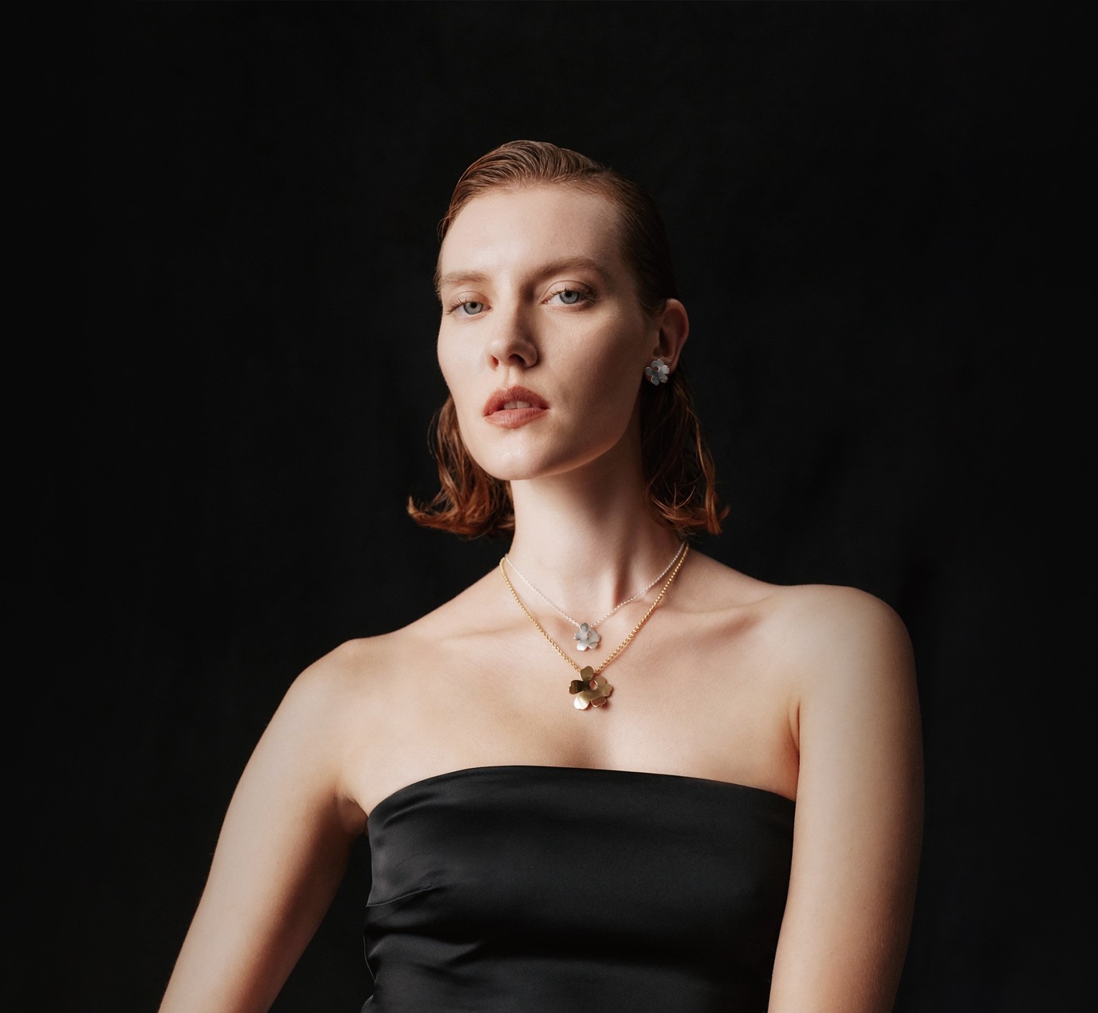 Mannequin portant des colliers Kalevala x Marimekko Unikko en argent et en or.