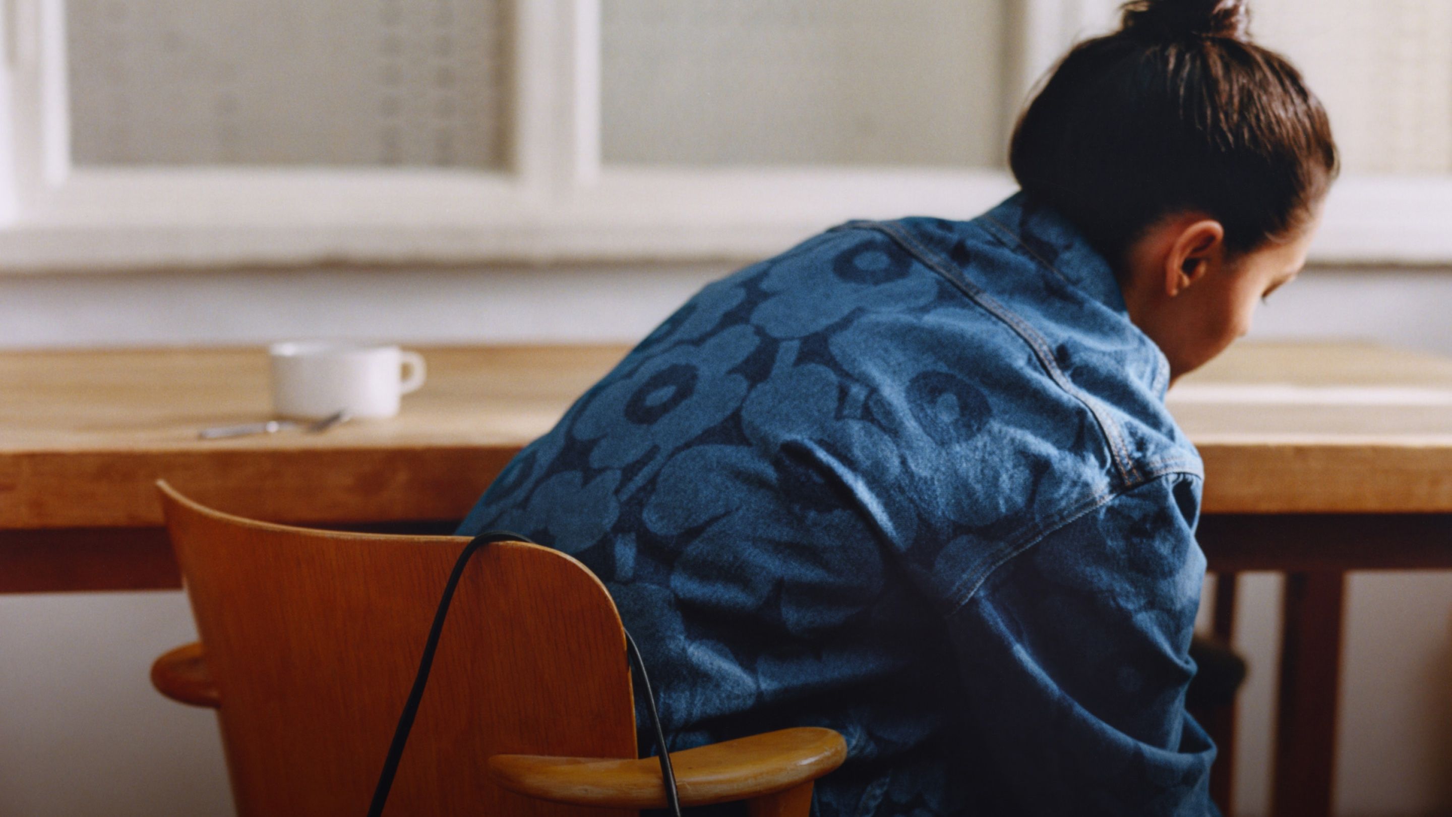 Model sitting on a chair wearing a Unikko Maridenim shirt.