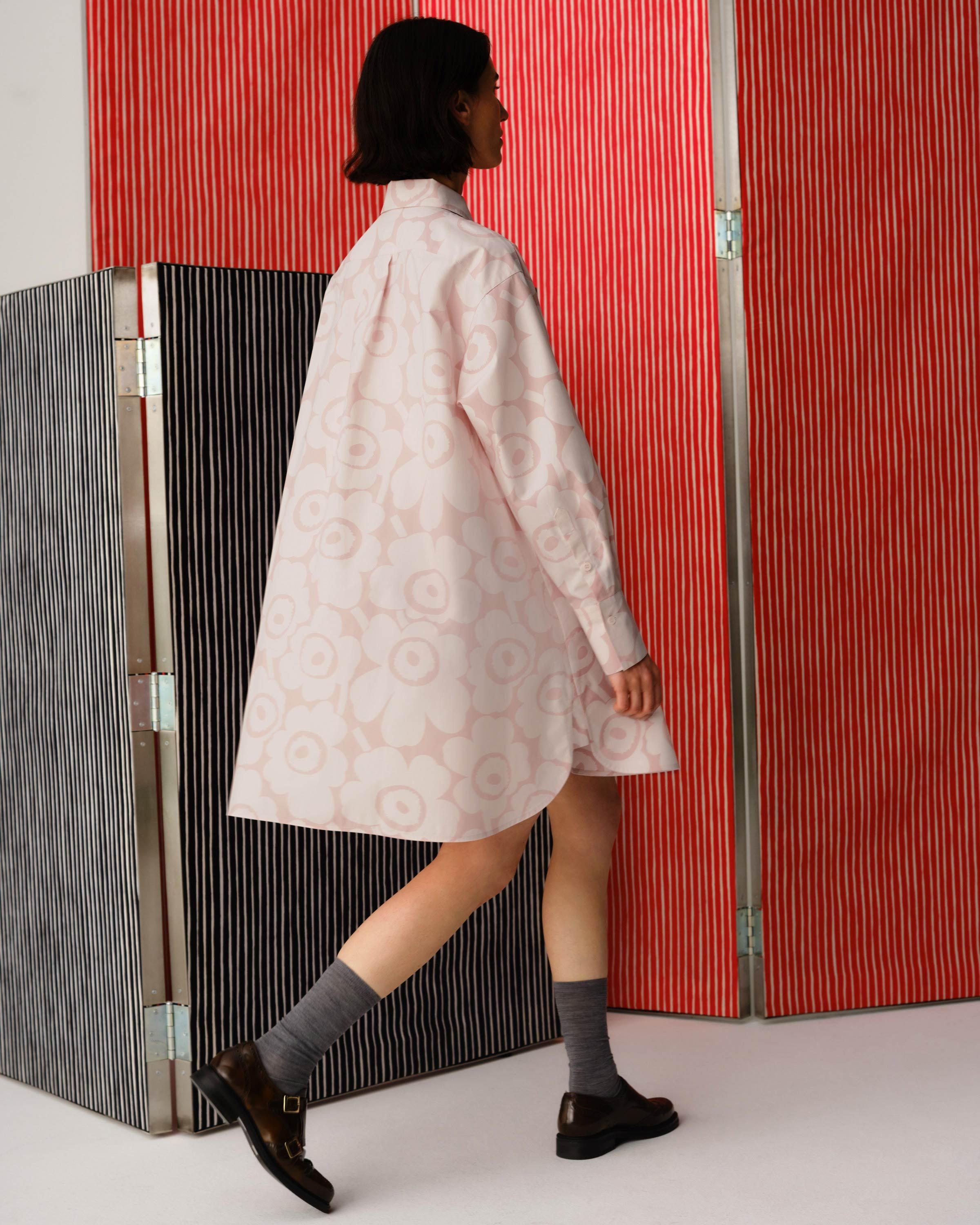 Model wearing long shirt in Unikko print.