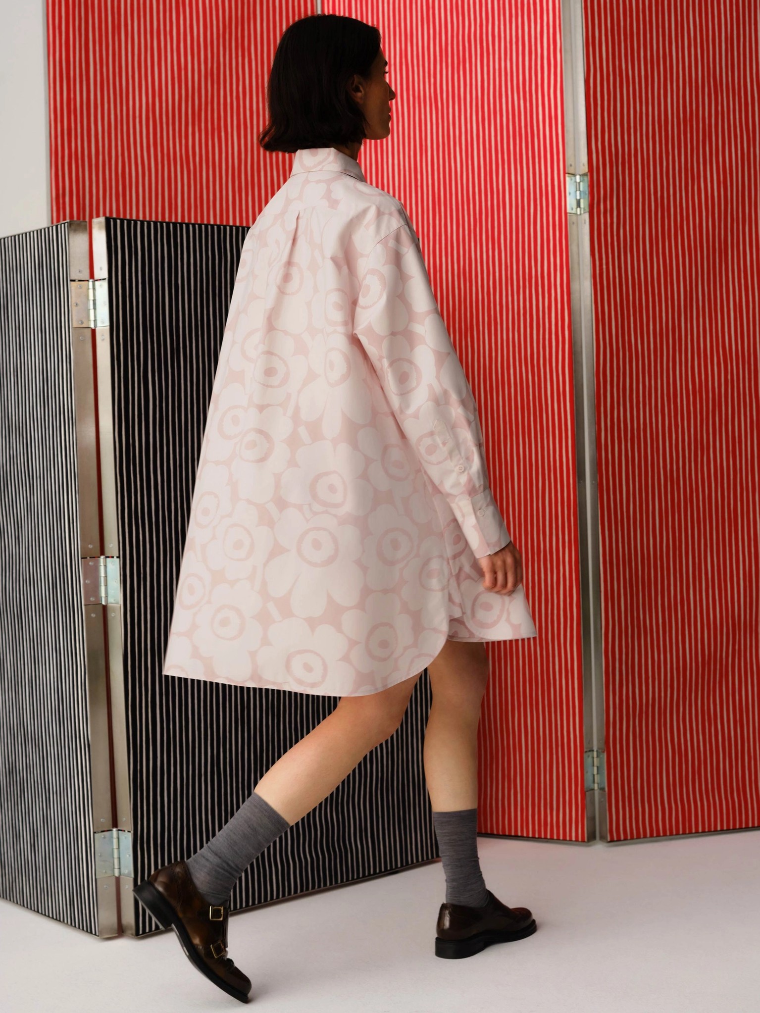 Model wearing long shirt in Unikko print.