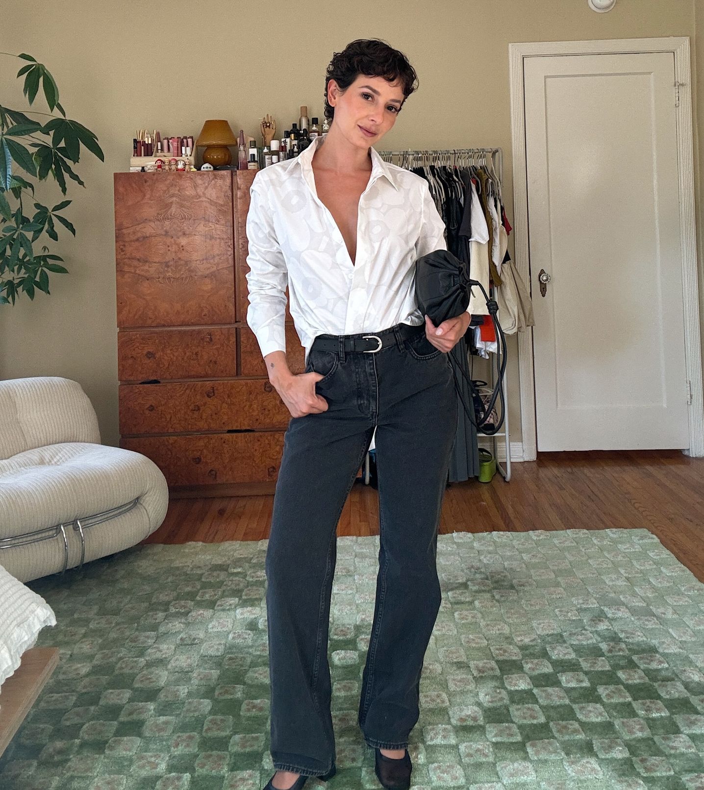 Alyssa Coscarelli dressed in black Maridenim jeans and a white Unikko collared shirt.