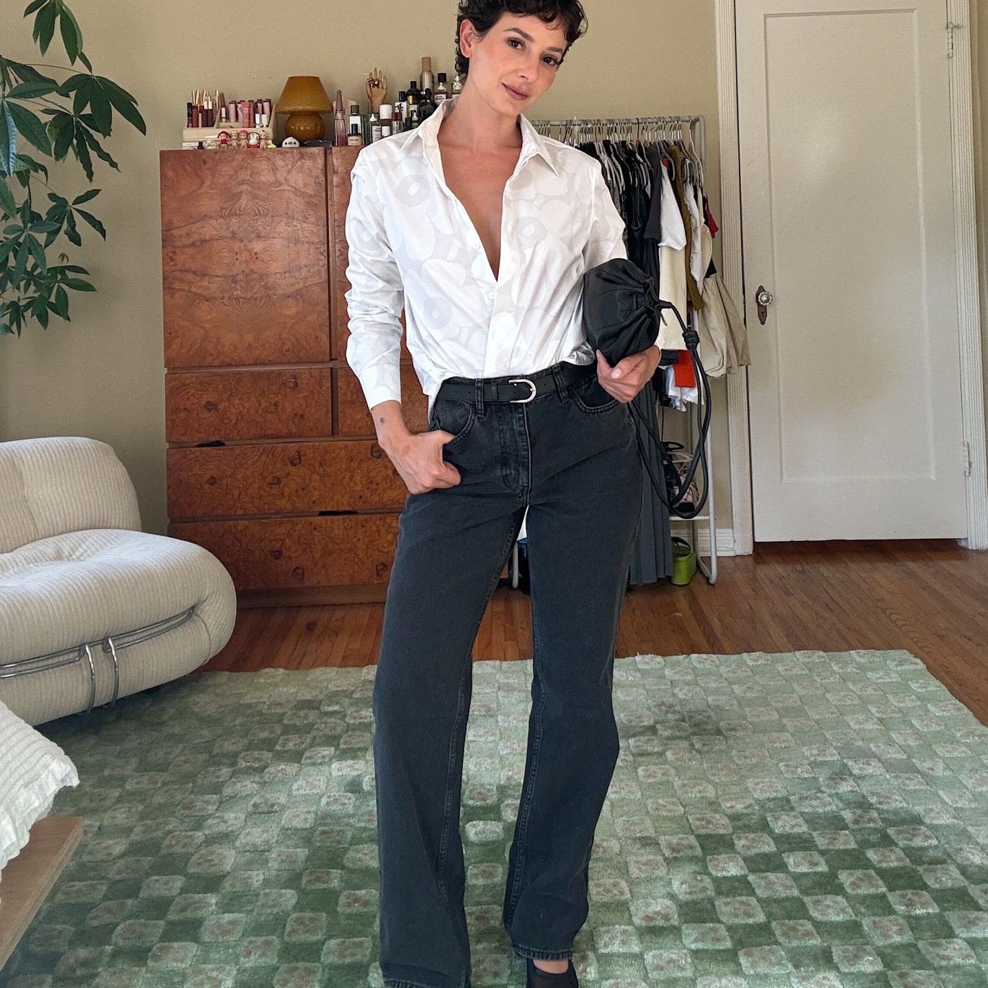 Alyssa Coscarelli dressed in black Maridenim jeans and a white Unikko collared shirt.
