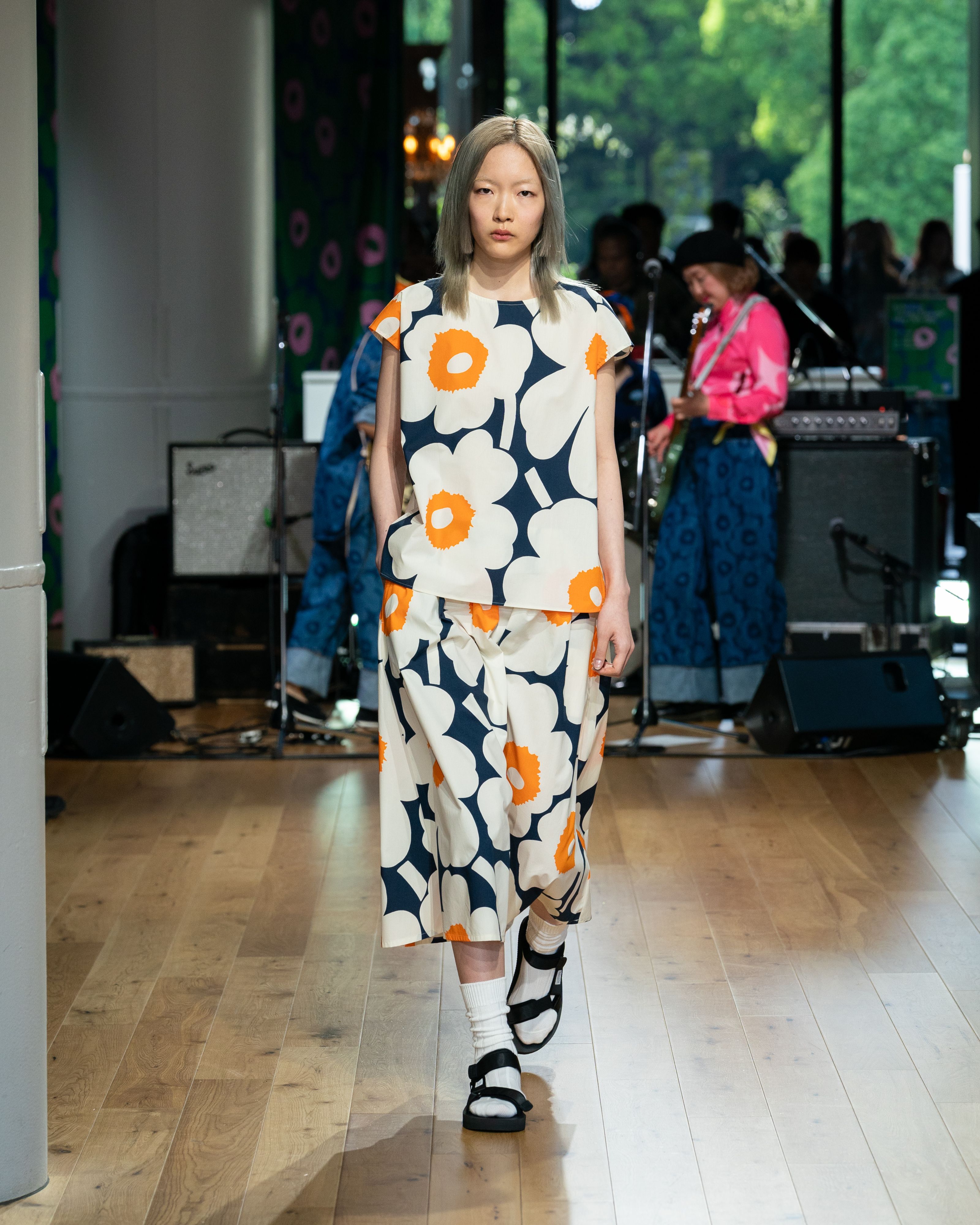 Model wearing blue-white-orange  t-shirt and skirt in Unikko pattern. 