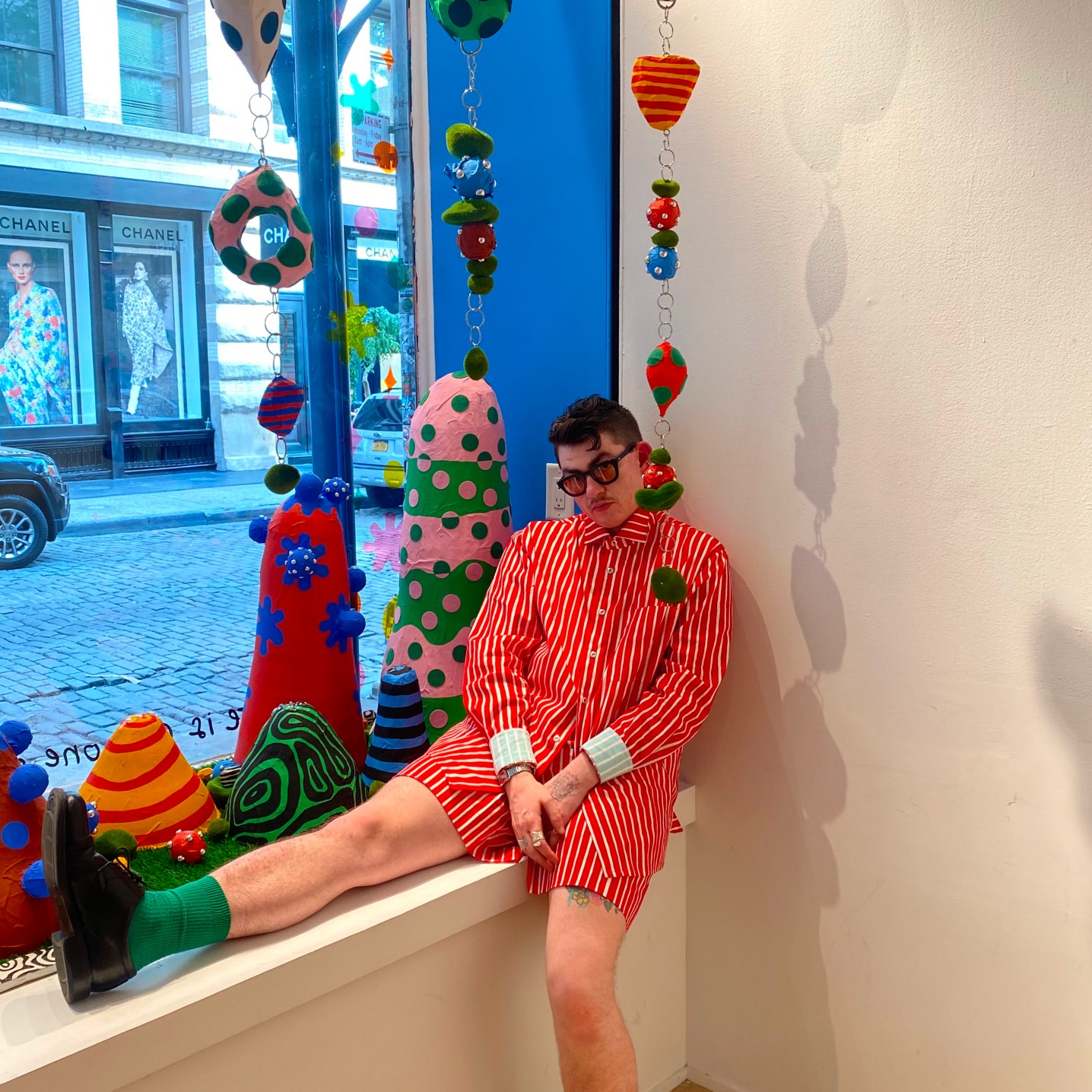 Zander Schlacter poseeraamassa suunnittelemansa ikkunan edessä New Yorkin myymälässä.