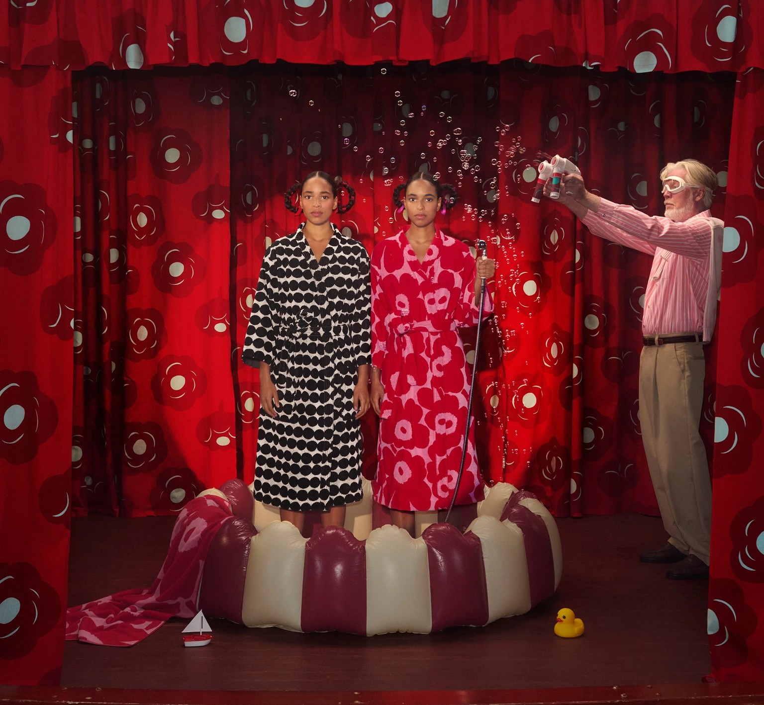Two models in bathrobes standing on a stage.