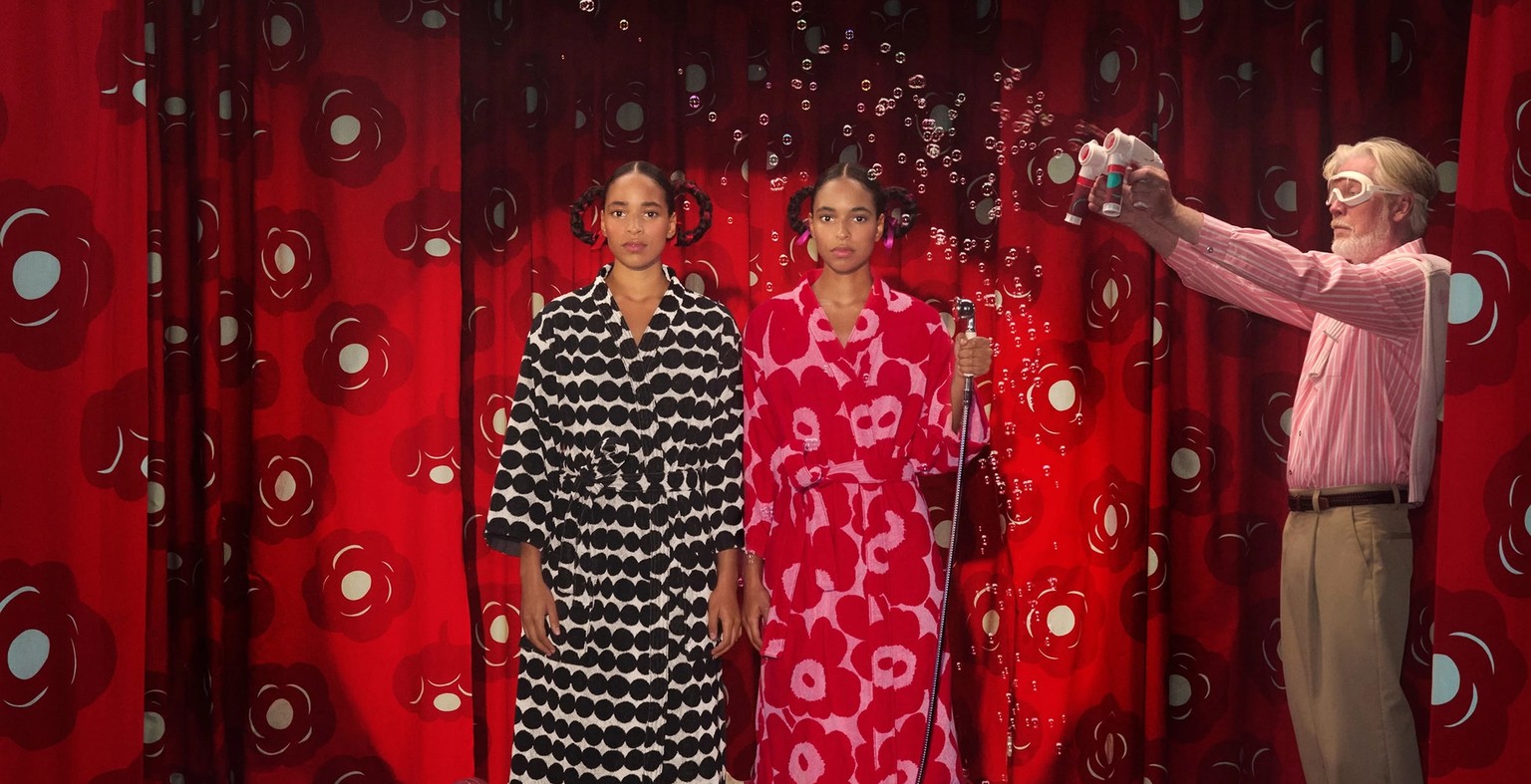 Two models in bathrobes standing on a stage.