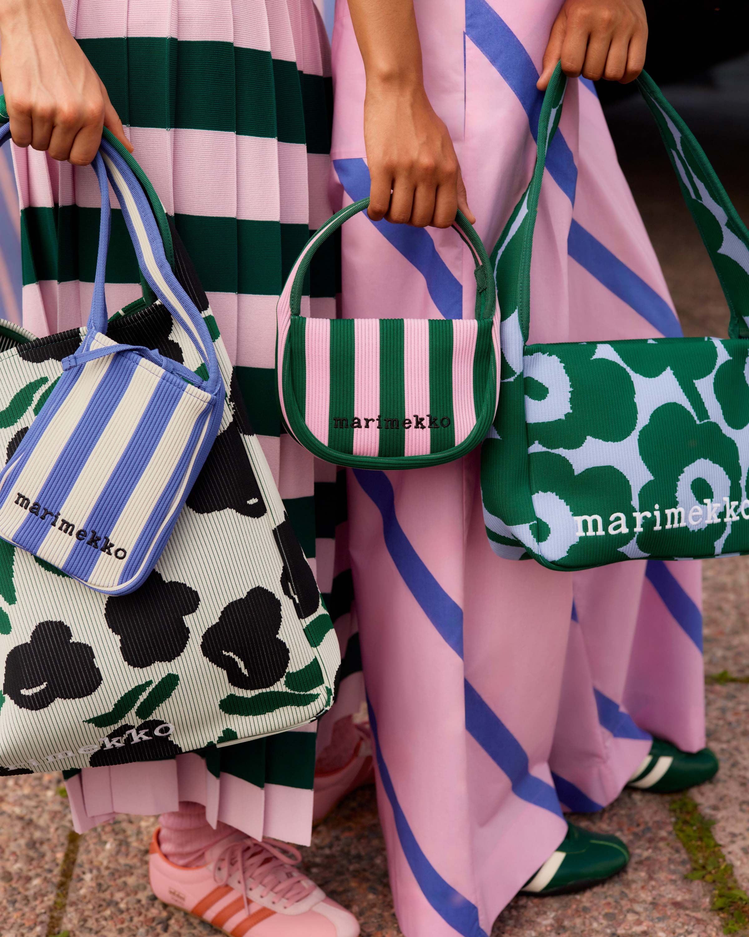 Models holding a selection of knitted bags in various color combinations. 
