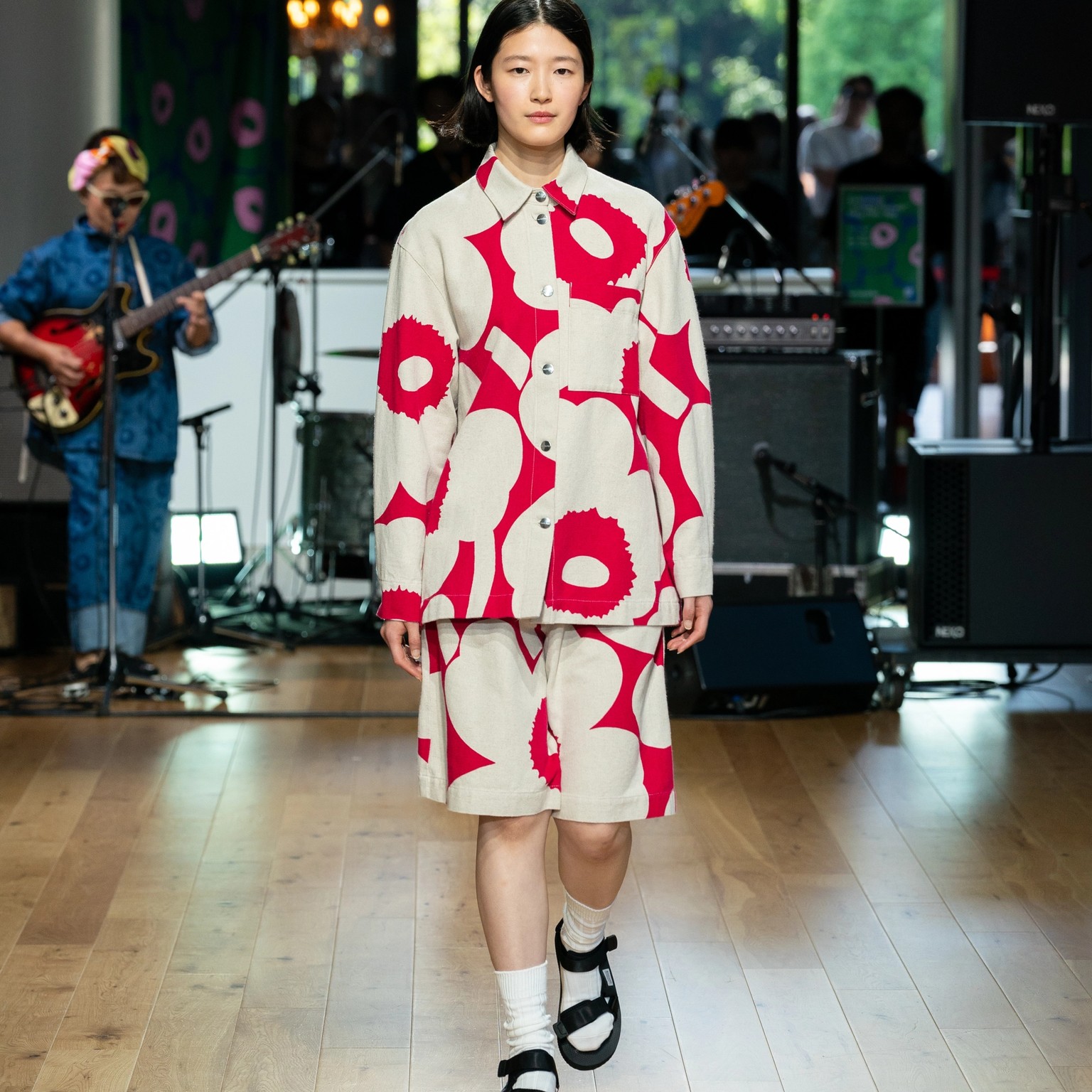 Model wearing oversized pink-white jacket and shorts in Unikko pattern.